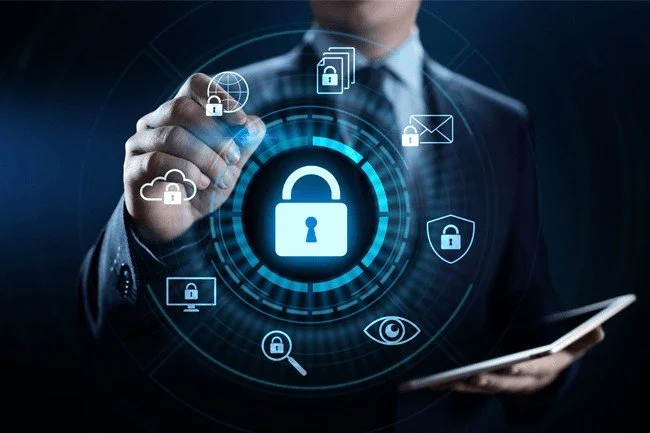 Businessman interacting with a digital lock icon and cybersecurity symbols on a transparent screen