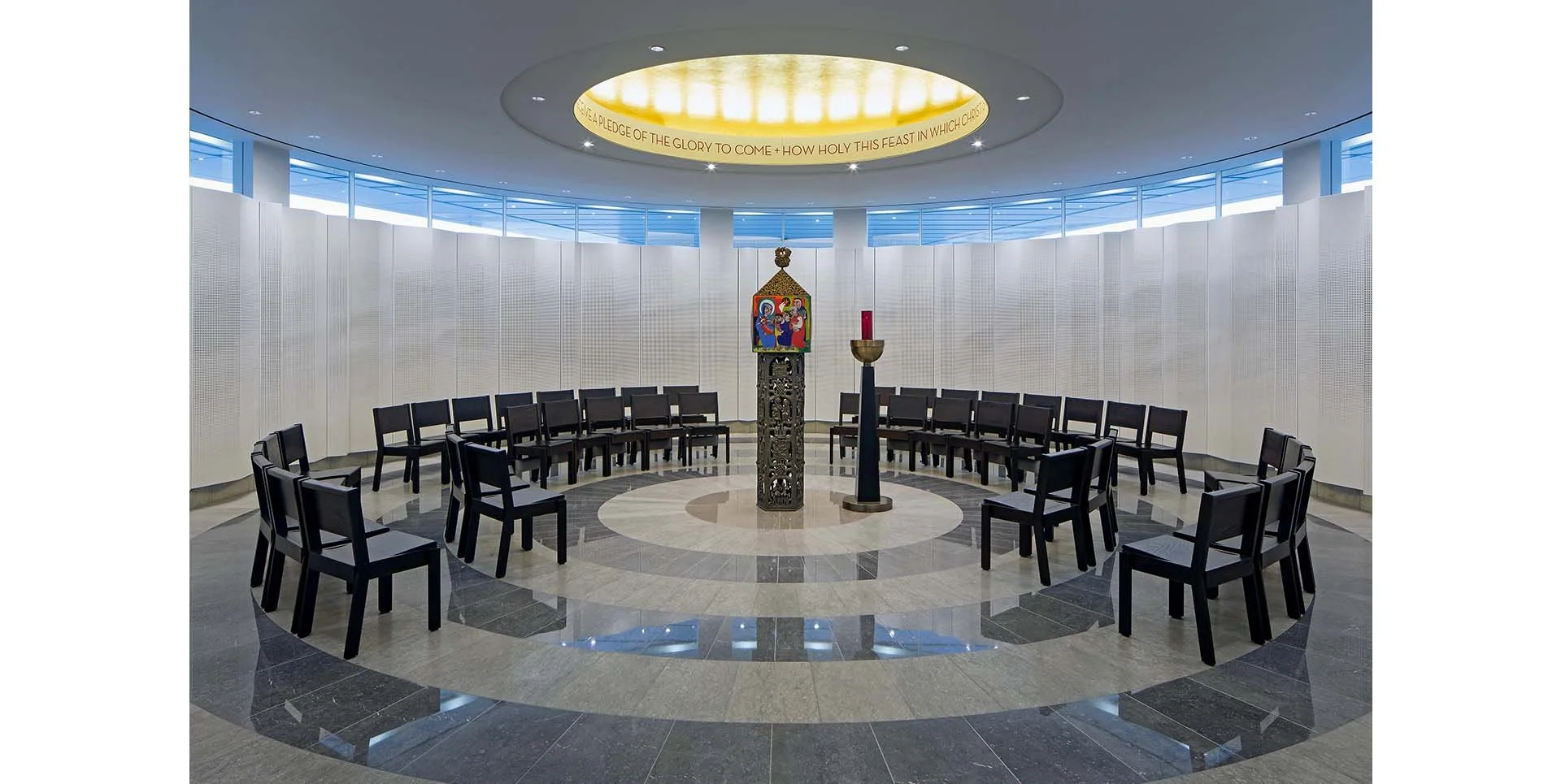 Circular church altar with altar candles, icon, and chairs arranged in a semi-circle