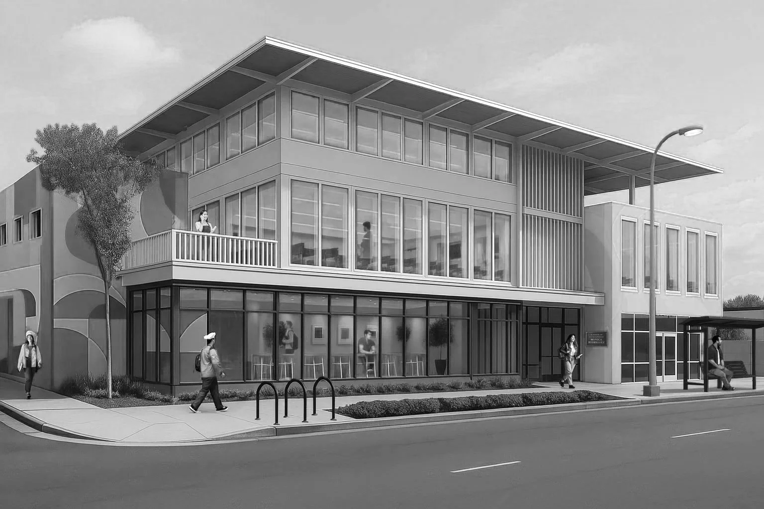 A modern, multi-story building with large glass windows, a balcony, and a bus stop with people around, on a city street.