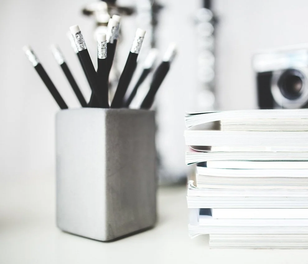 Un pot avec plusieurs crayons, un tas de plusieurs cahiers, pour écrire, créer, communiquer