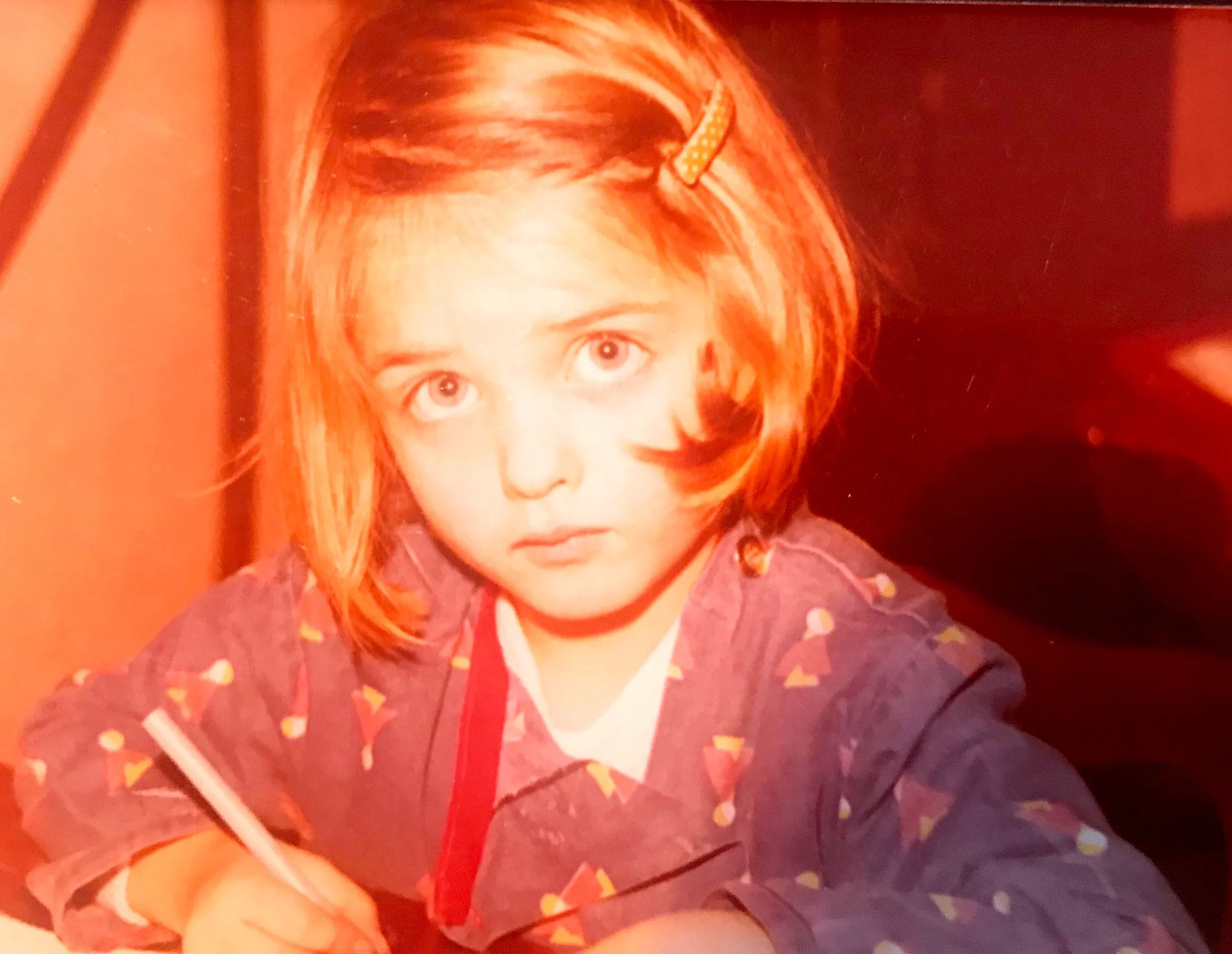Emmanuelle Hardouin, petite fille. Un crayon à la main, elle est en train d'écrire. Une passion qui ne l'a jamais quittée