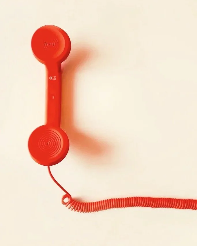 Telephone rouge avec fil, symbolisant l'échange et l'écoute