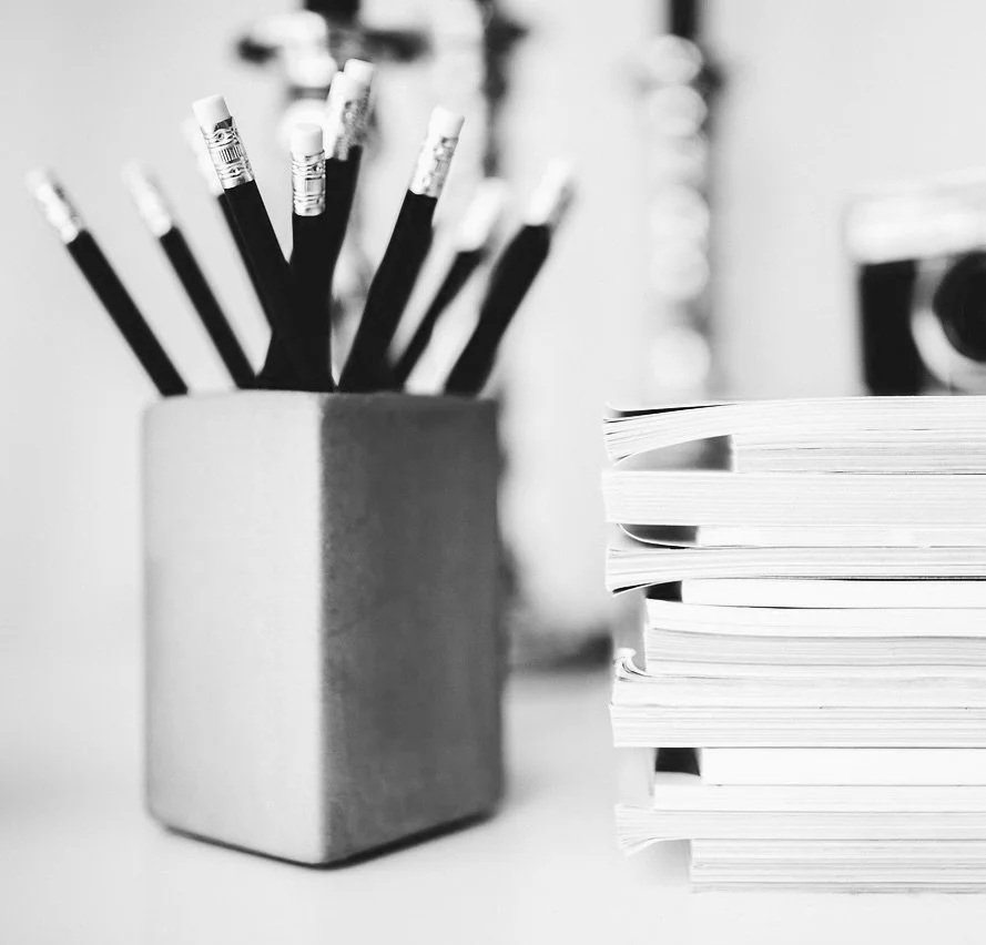 uUn pot contenant des crayons et des carnets de notes empilés. Prendre le temps d'écrire, storytelling et redactionnel