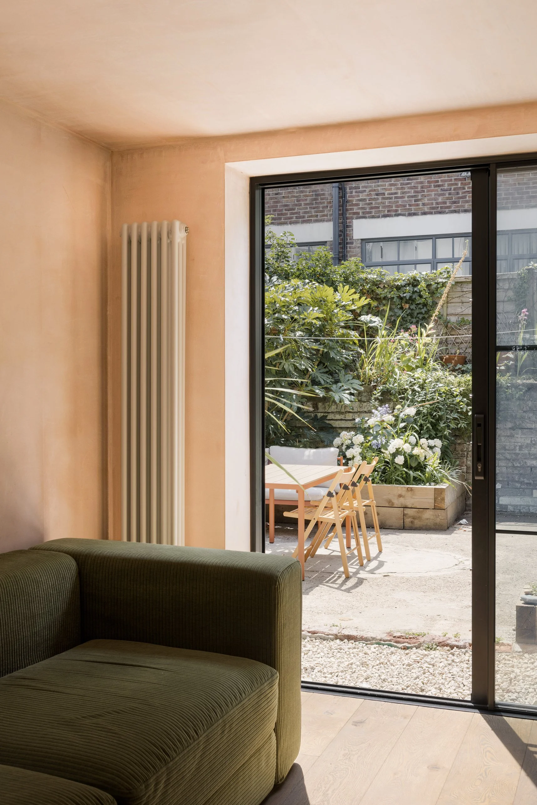 Lower-ground-floor living space opening directly onto the planted courtyard garden