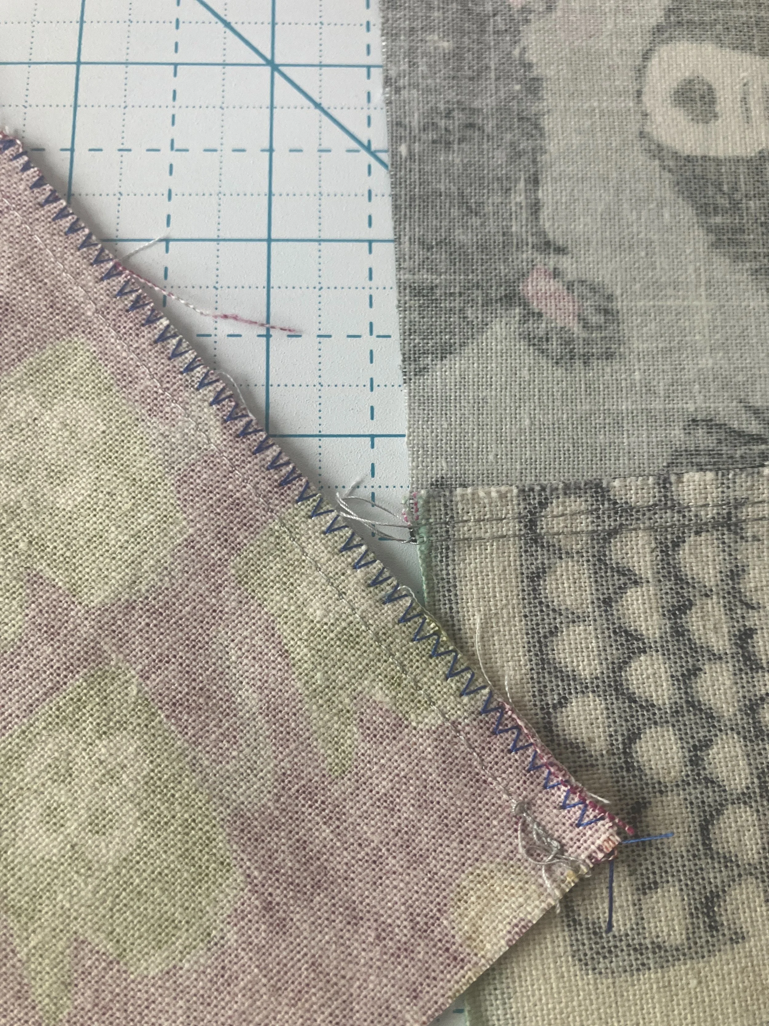 A close up of two seams on linen squares, one with zigzag and one with double lines.