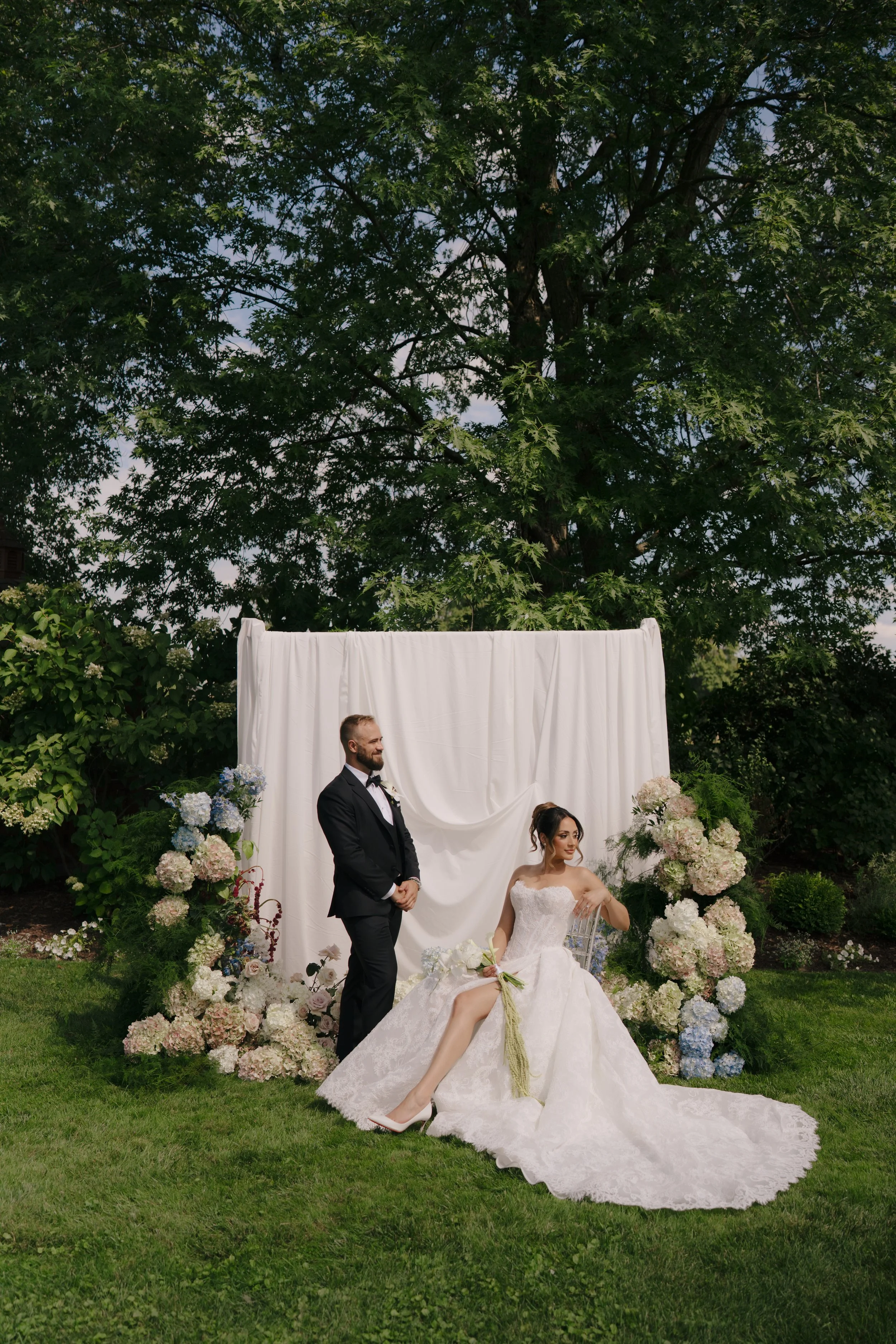 Luxury Toronto wedding couple in front of a custom floral installation by Derêves Studio wedding florist and planner