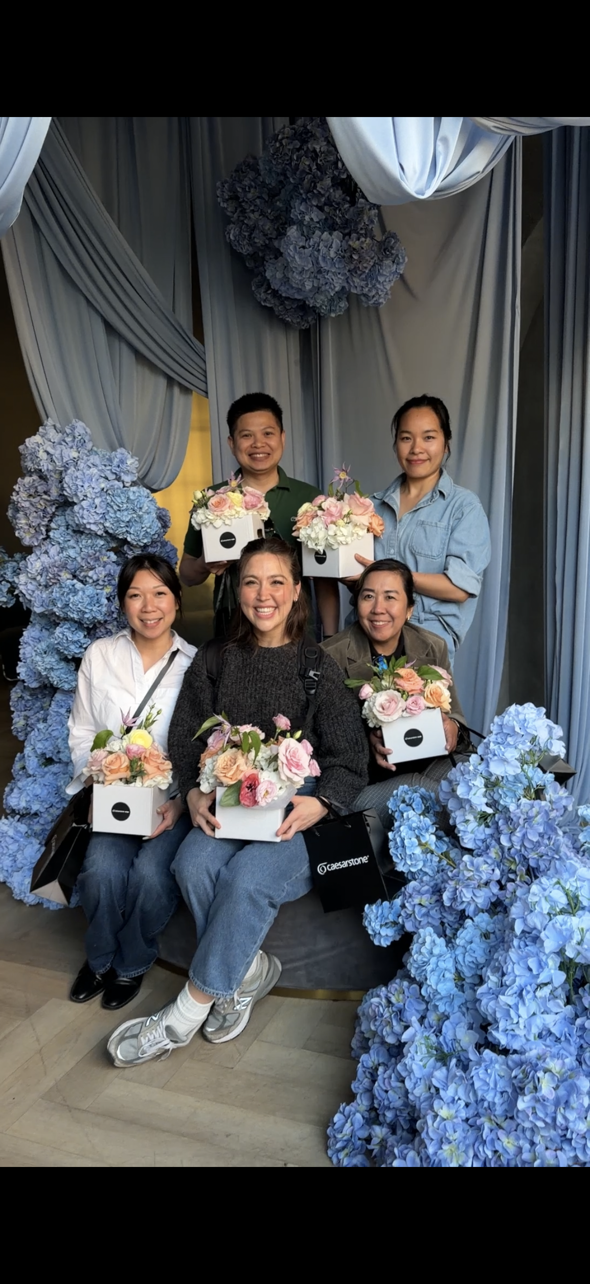 A private flower workshop setup in Toronto with fresh flowers, floral tools, and Caesarstone countertop samples for a client appreciation event.