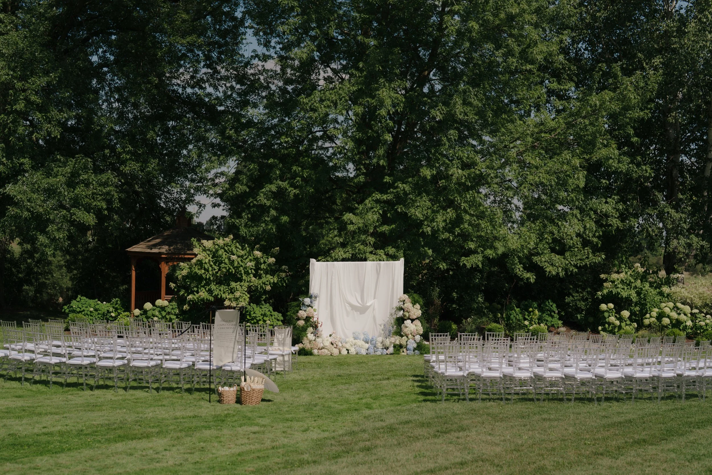 Soft white draping framing a modern ceremony styled by Dereves, Toronto wedding florist and planner