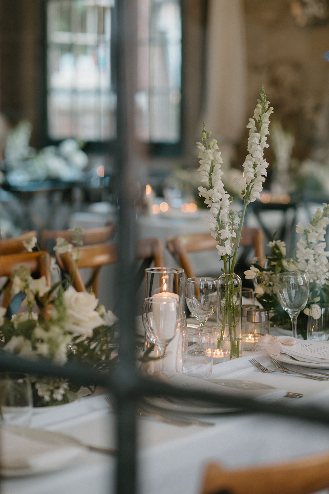 Elegant white florals and candle arrangements for a whimsical wedding at Caffino, created by Dereves Studio, a Toronto wedding florist and coordinator specializing in intimate weddings.
