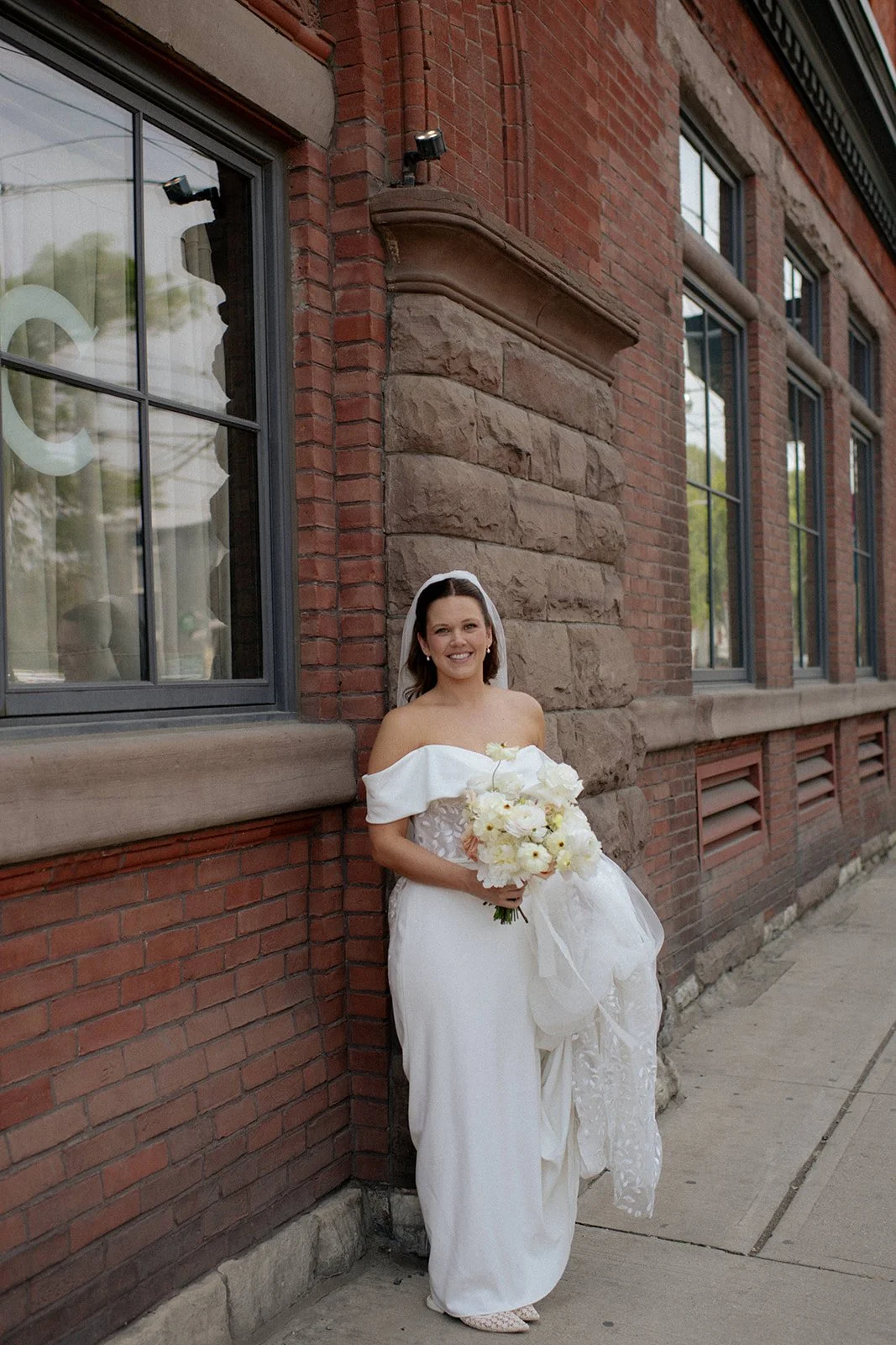 Bride in wedding dress holding a bouquet of white flowers, best florist in Toronto