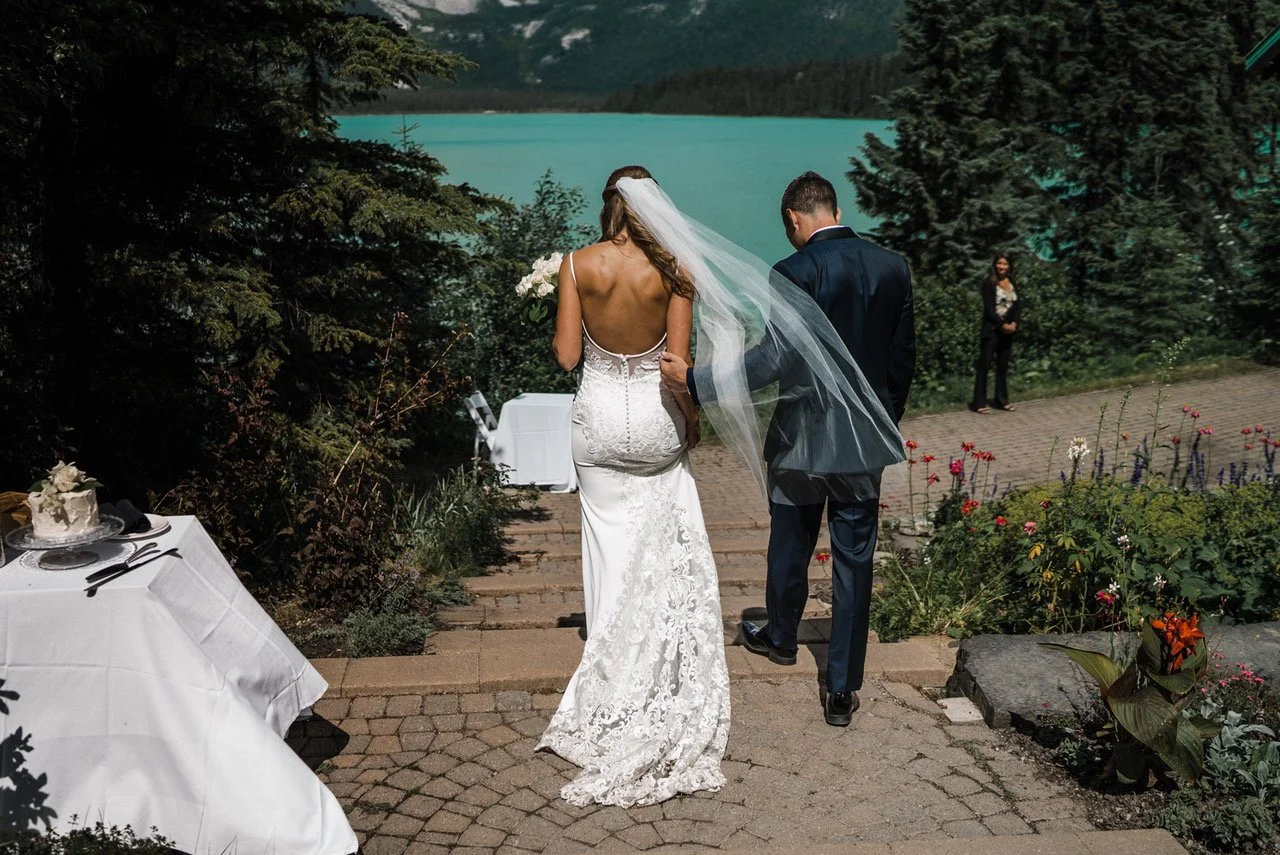 A bride and groom walk down the stairs of the landing - a popular ceremony location for couples who elope and Emerald Lake Lodge