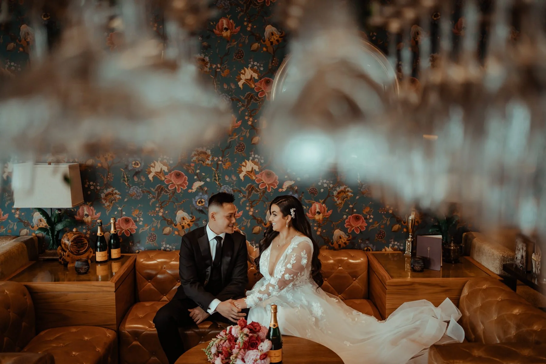 A bride and groom look at each other in a speakeasy.