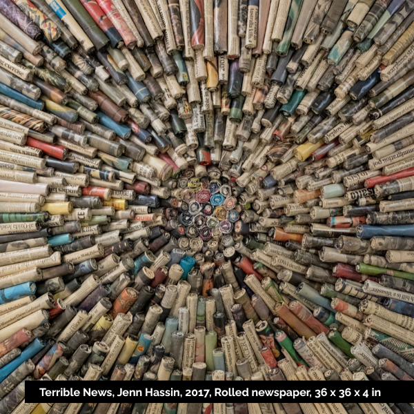 A circular arrangement of rolled newspapers with a hollow center.