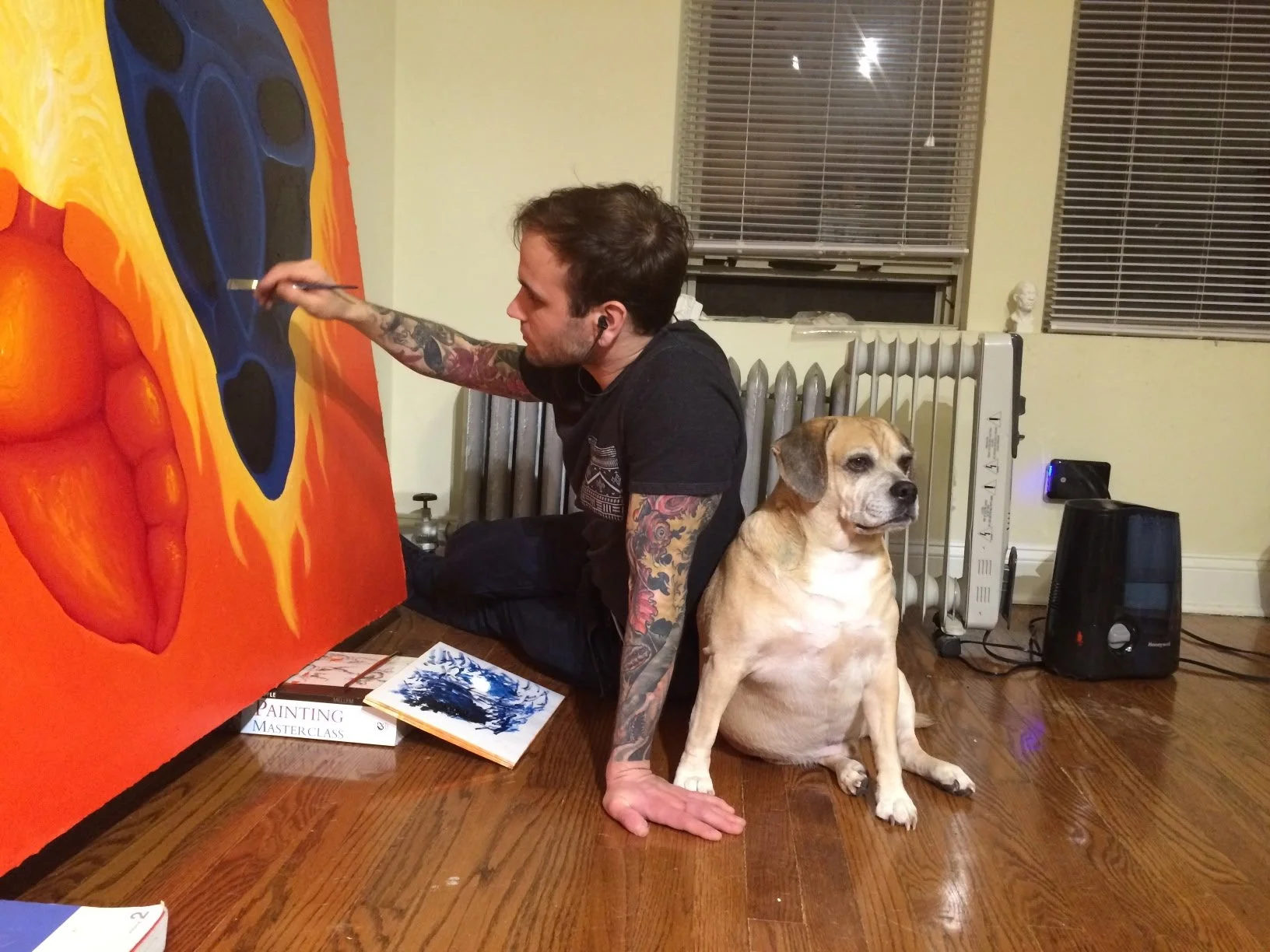 Artist painting on floor with dog