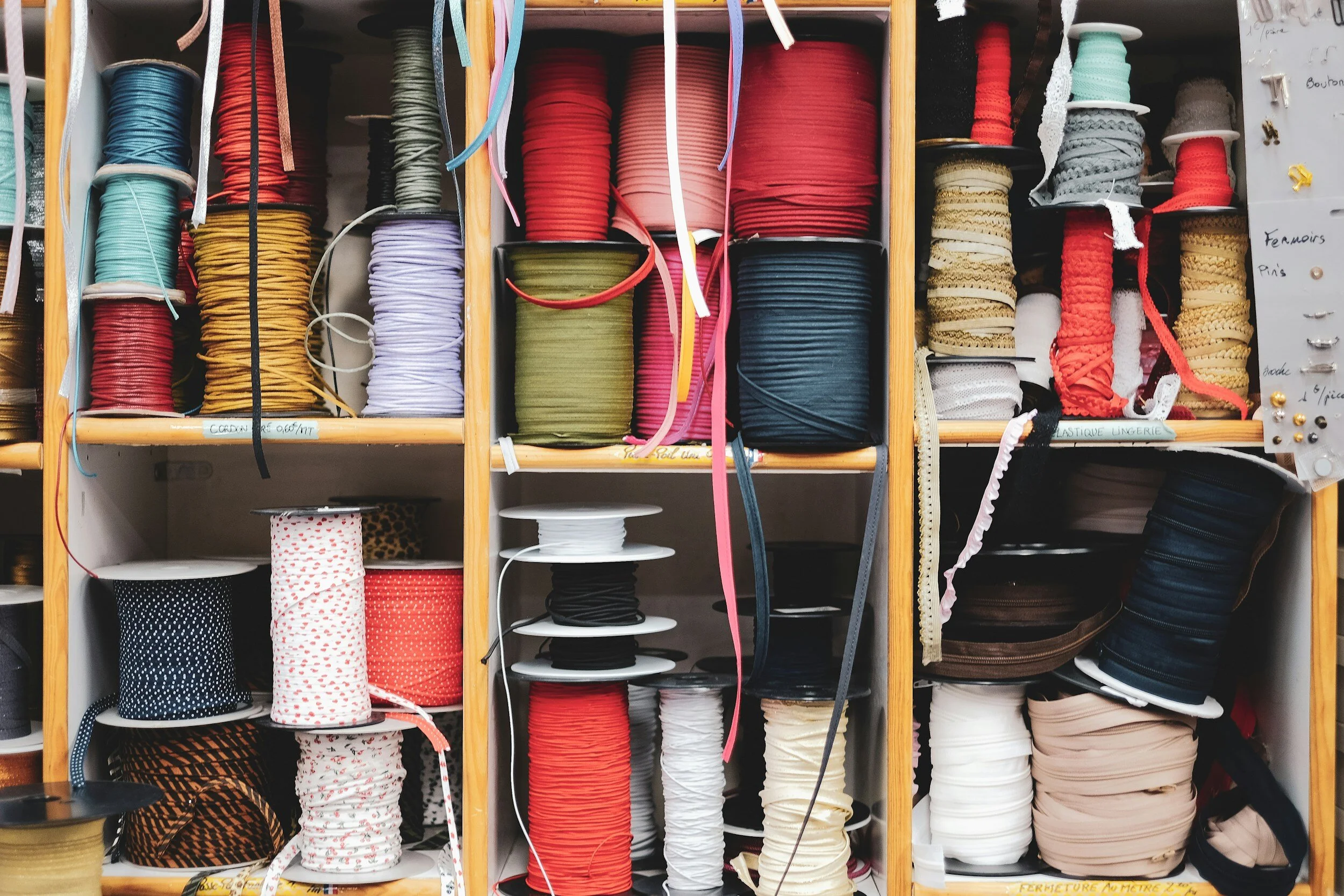 Shelves filled with colorful spools of ribbon, lace, and trims.