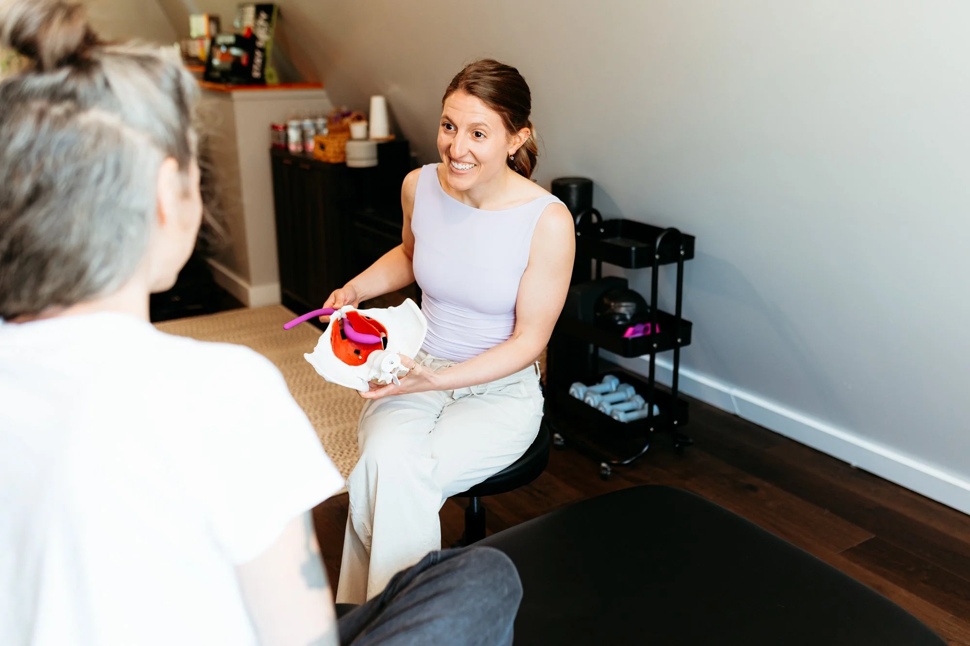 Kaylee Pobosik, a pelvic health physical therapist, using a wand for demonstration instead of a pelvic model with a patient