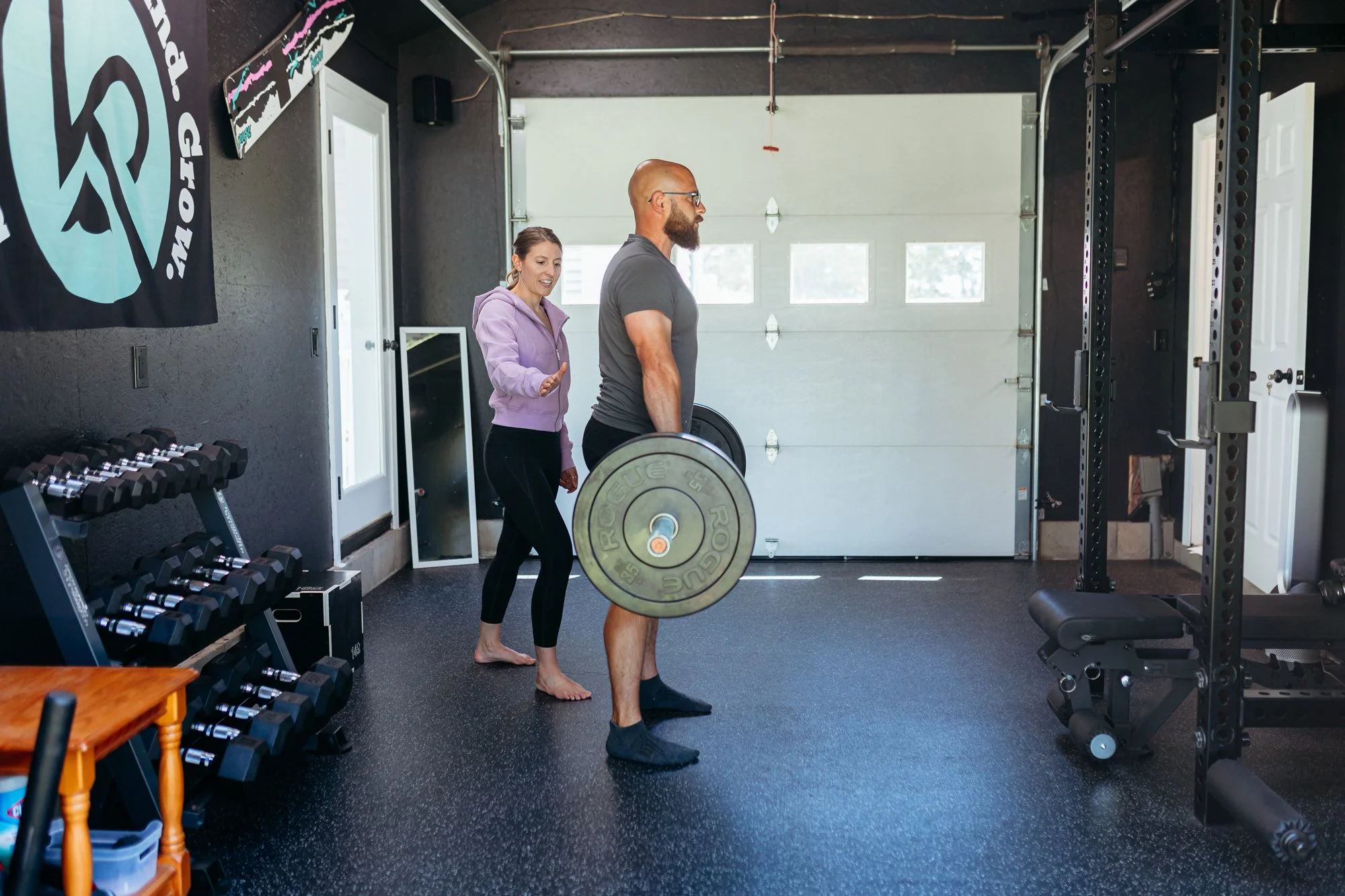 Kaylee Pobosik, a physical therapist working with an athlete holding a barbell inside her physical therapy clinic