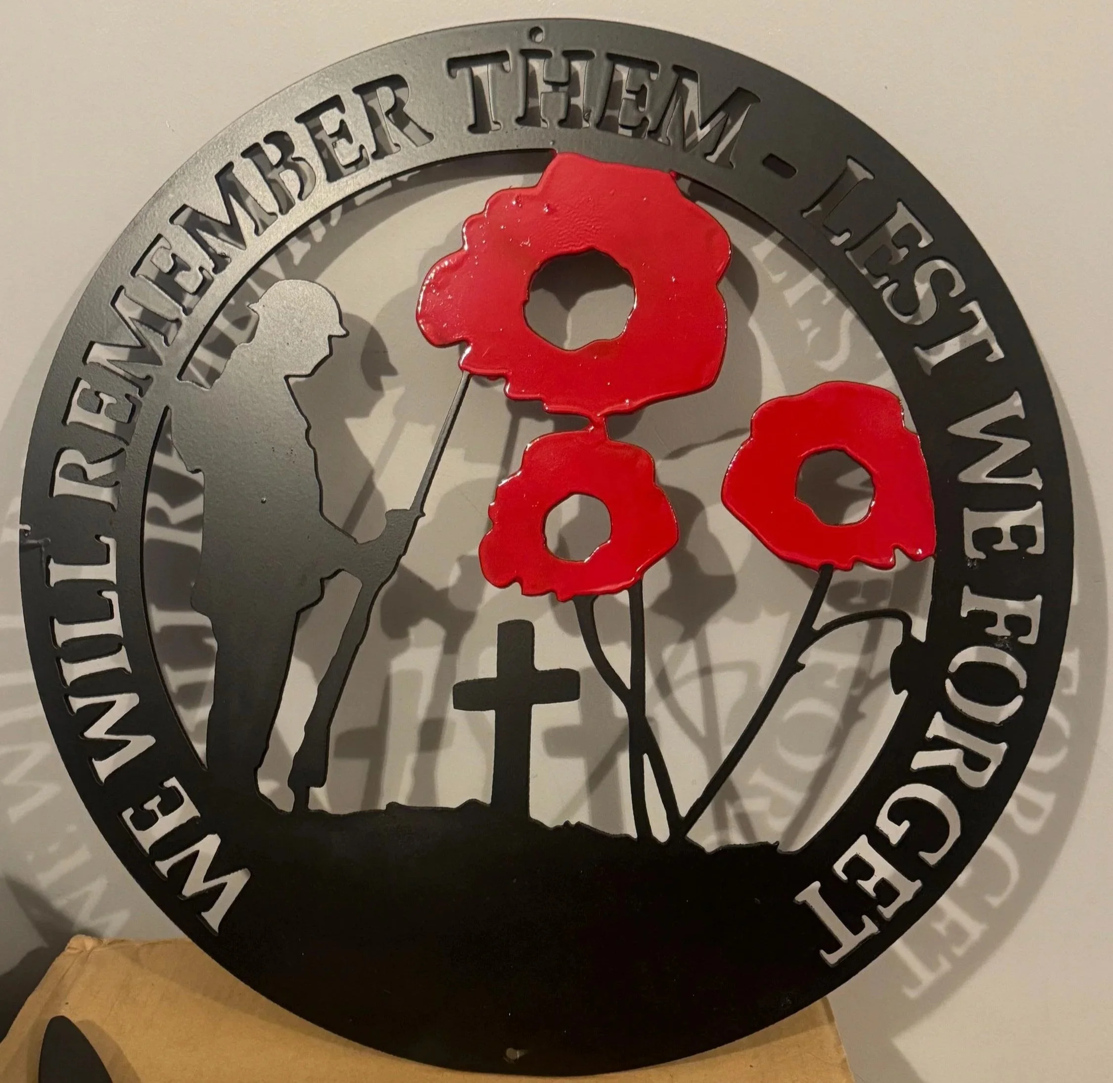 Lest We Forget fallen soldier metal wall sign with red poppies suitable for remembrance gardens.