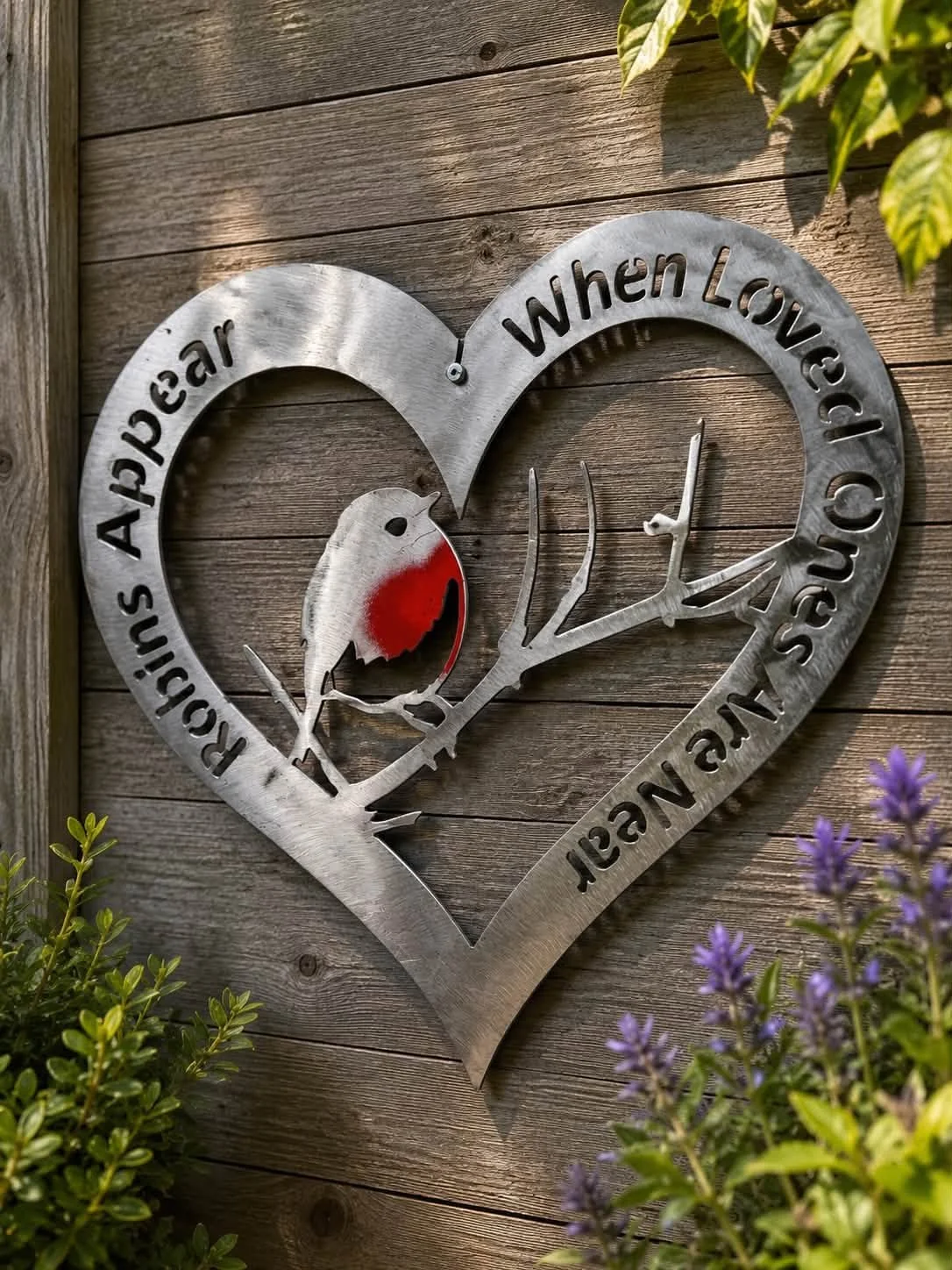 Handmade Robin Memorial Metal Wall Art featuring the quote Robins Appear When Loved Ones Are Near hanging on a wooden garden fence.
