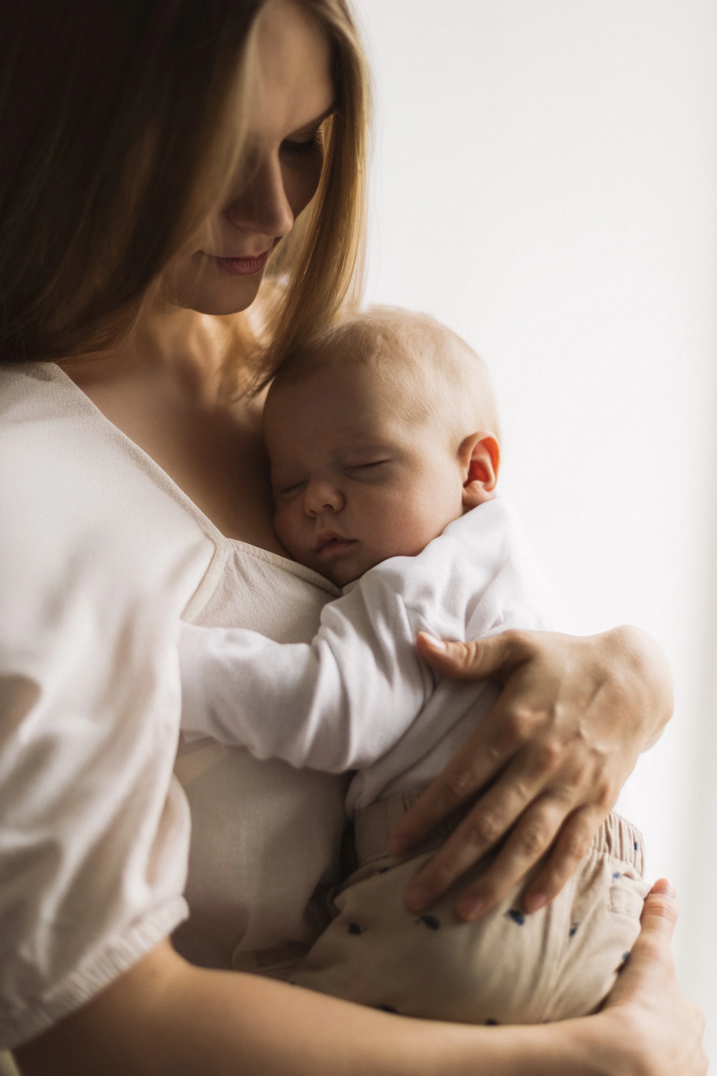 Eine Frau hält ein schlafendes Baby in den Armen.