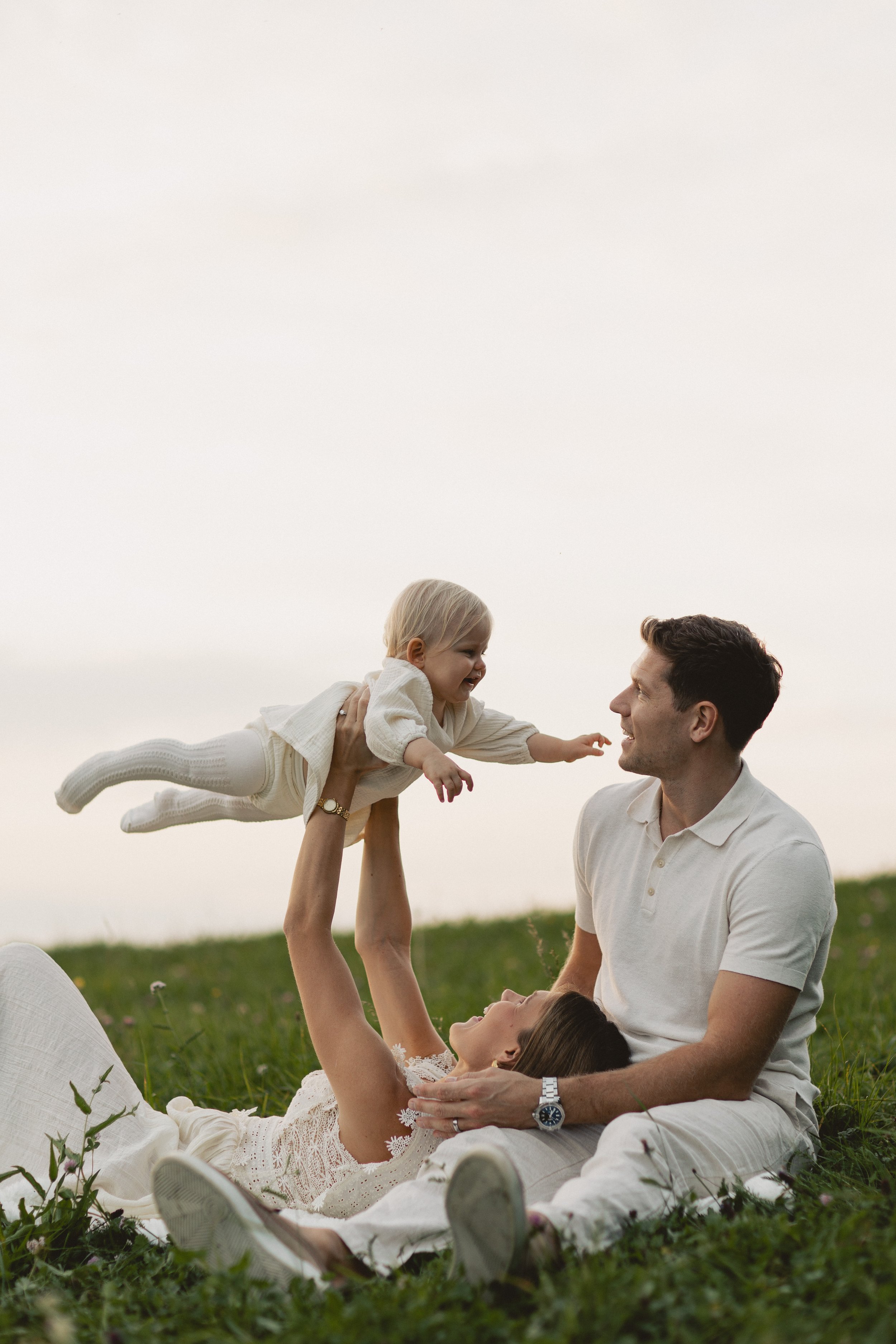 Mutter trägt ihr Kind auf dem Arm bei einem Familienshooting im Freien in Bayern. Mother holding her child during an outdoor family session in Bavaria.