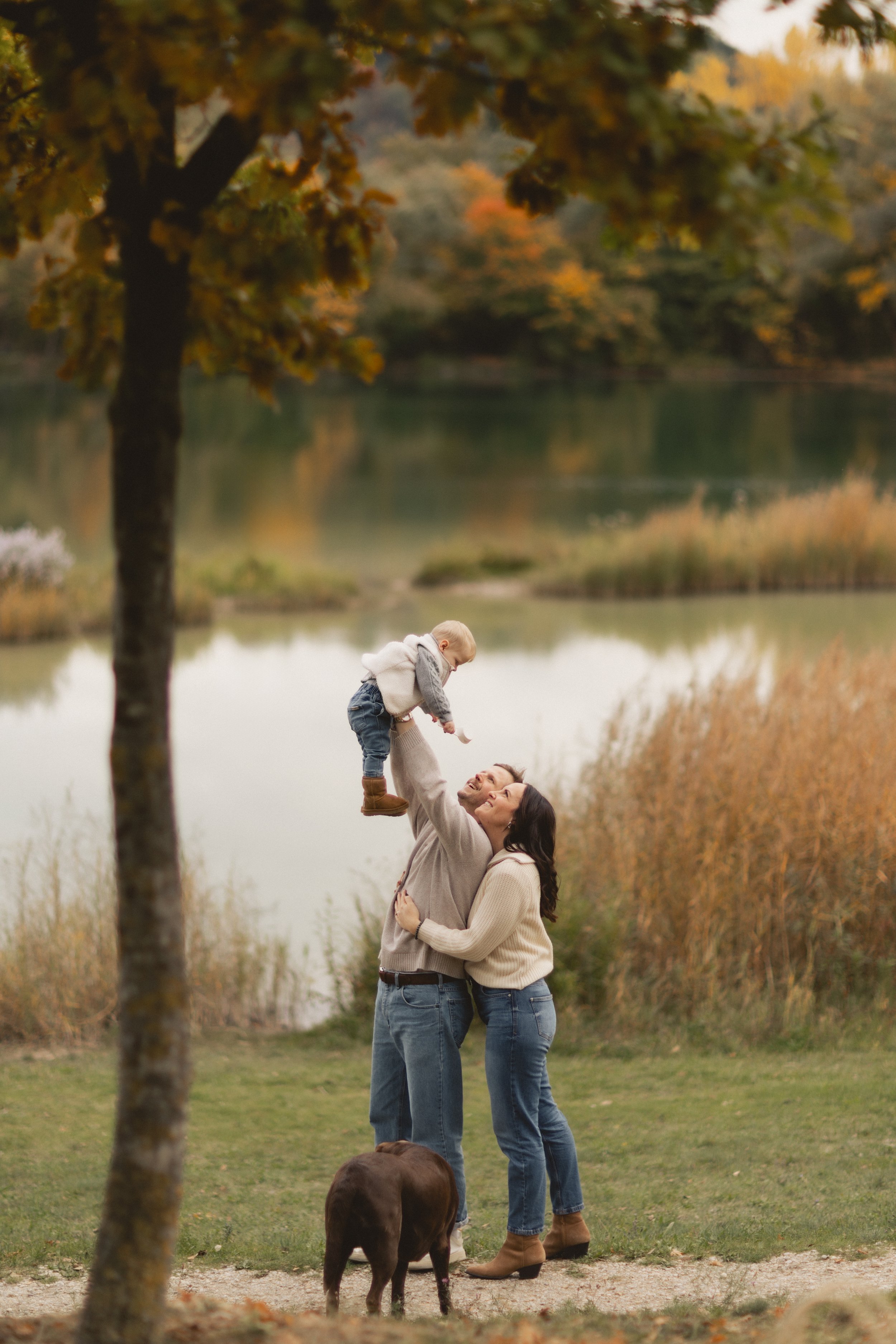 Eltern halten ihr Kind im Arm bei einem Outdoor-Familienshooting in Landshut, echte und bleibende Erinnerungen. Parents holding their child during an outdoor family session in Landshut, genuine and lasting memories.