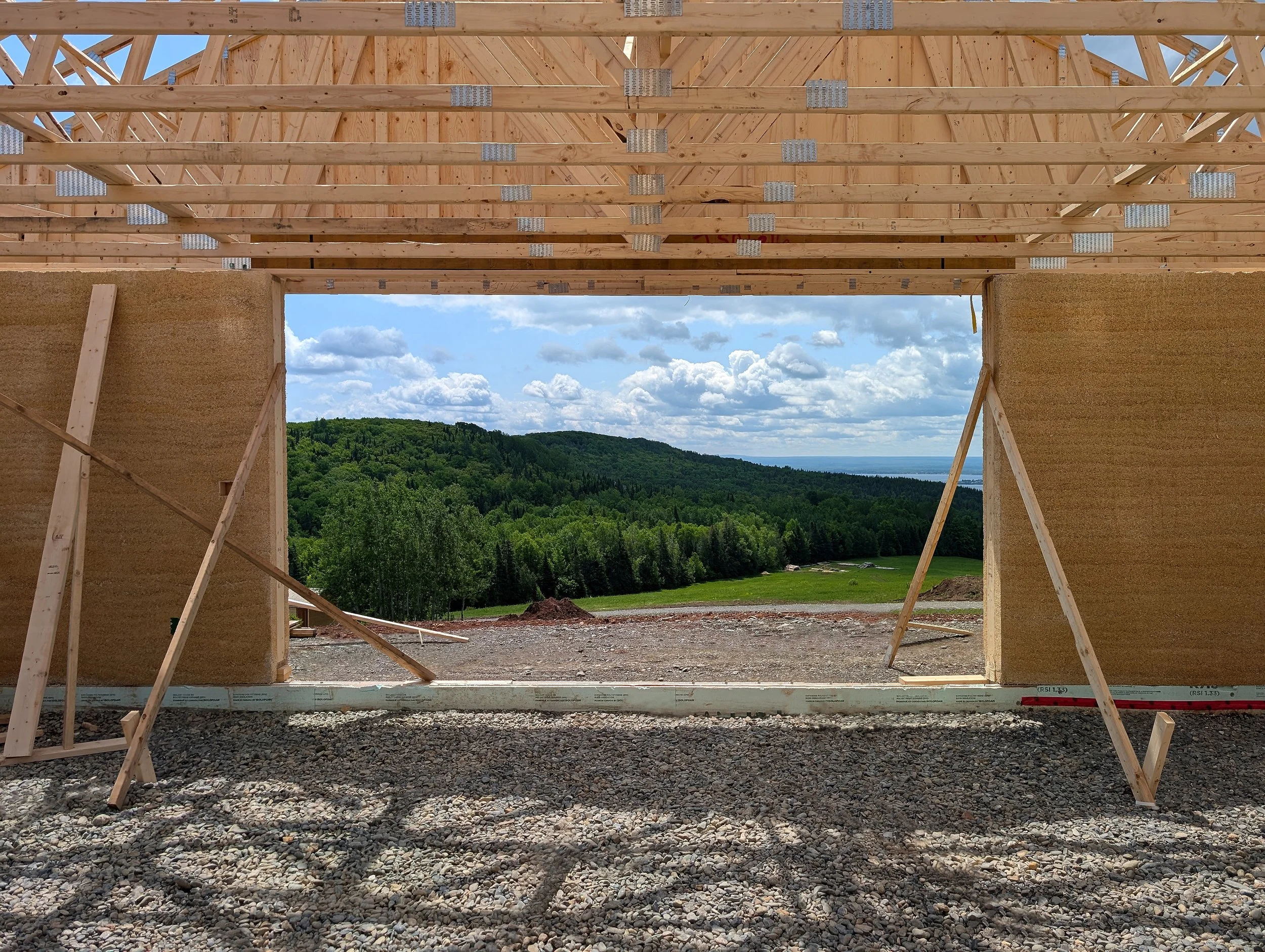 Architecture biosourcée avec béton de chanvre et ferme de toit en bois.