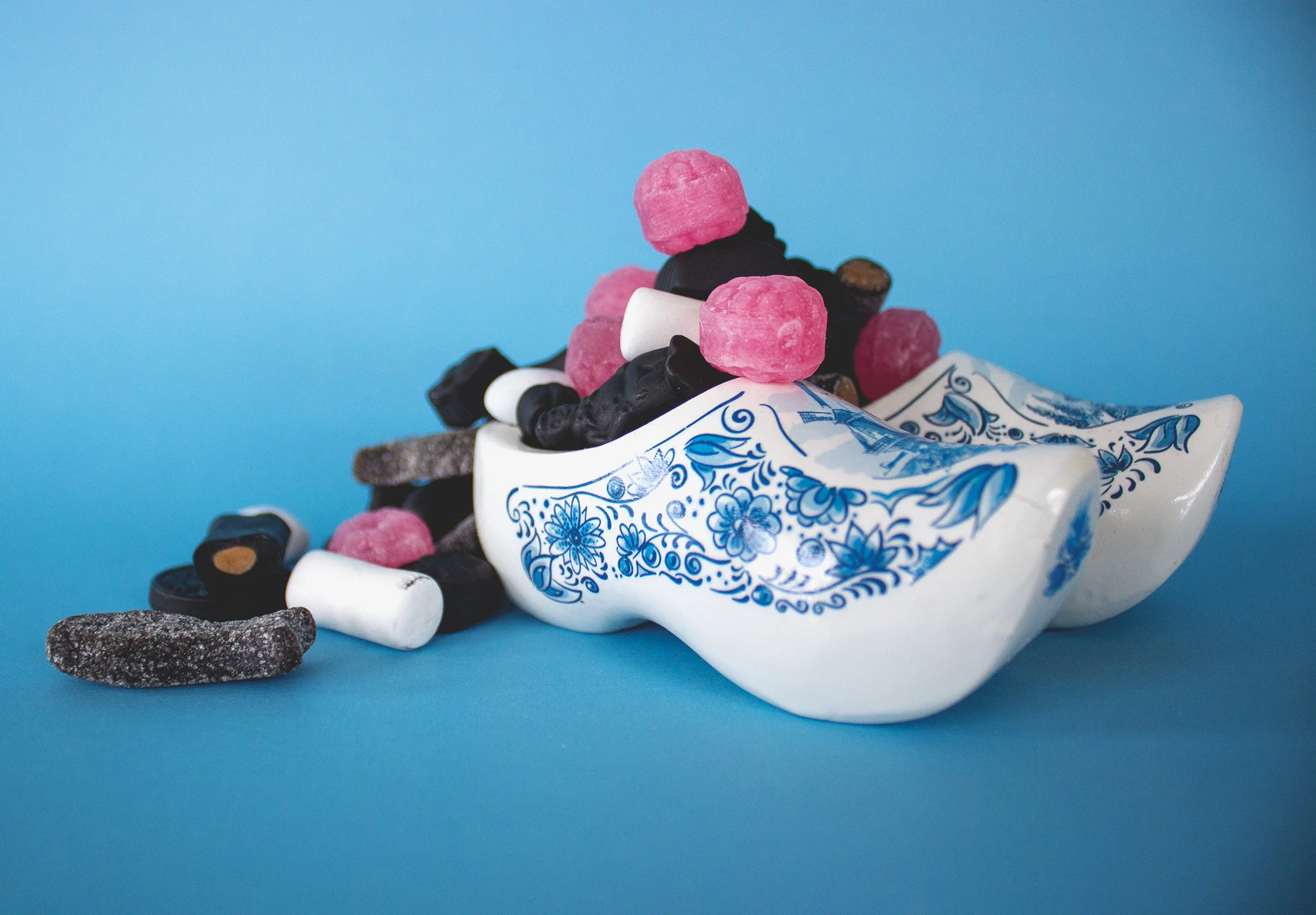 Delft blue clogs hold a pile of candy