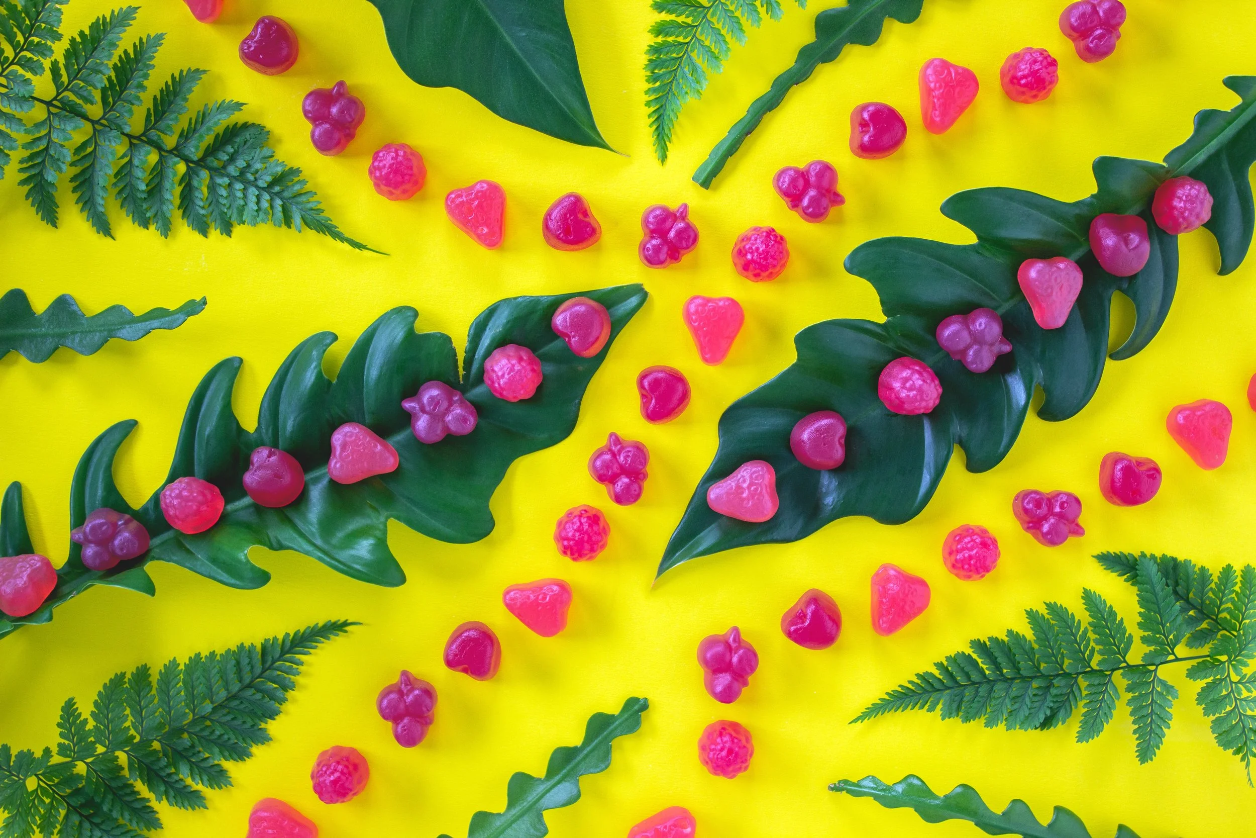 Vibrant vegan gummies contrast green leaves and flora