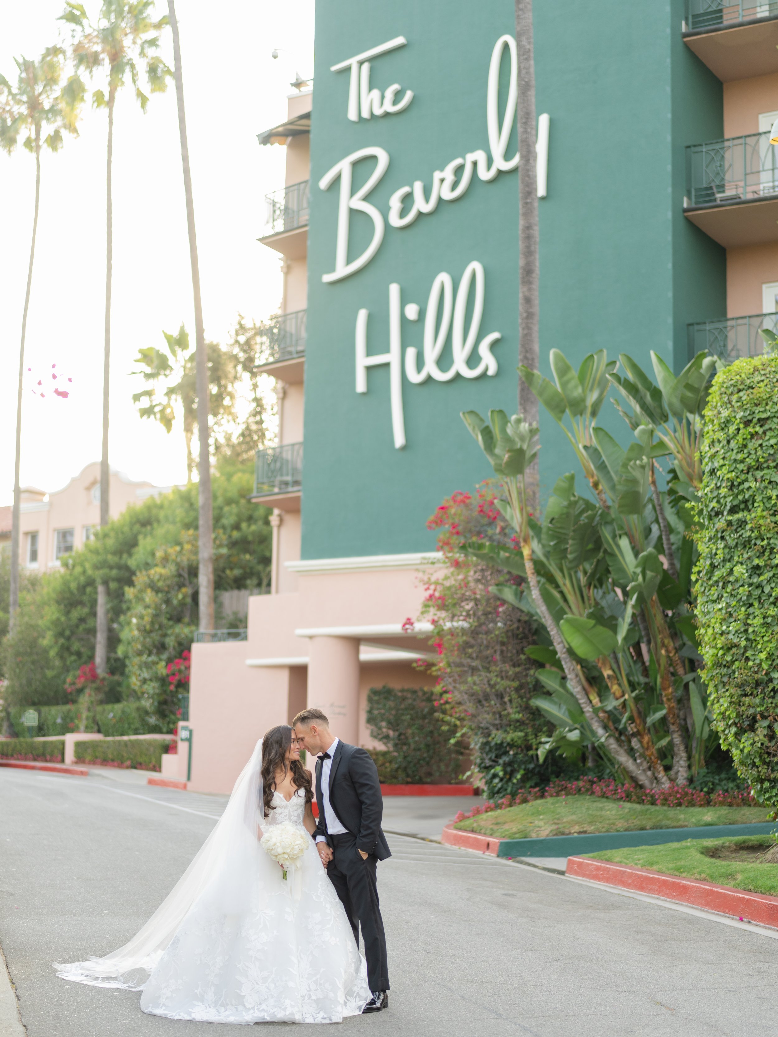 Beverly Hills wedding Monique Lhuillier bride with Michael Costelo veil in front of Beverly Hills Hotel iconic sign by luxury wedding photographer Amanda Watson