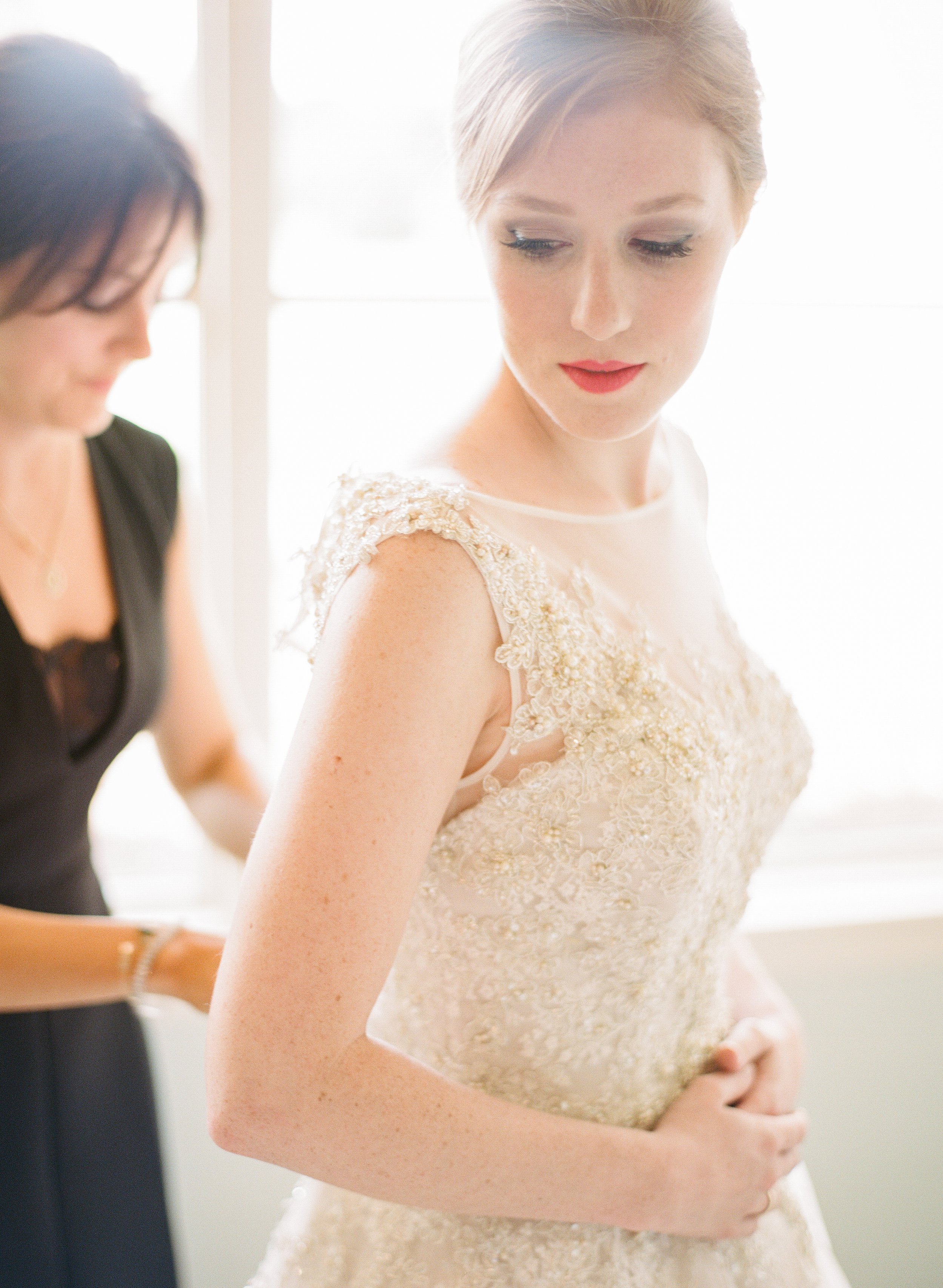 Country club wedding bride getting dressed by luxury wedding photographer Amanda Watson