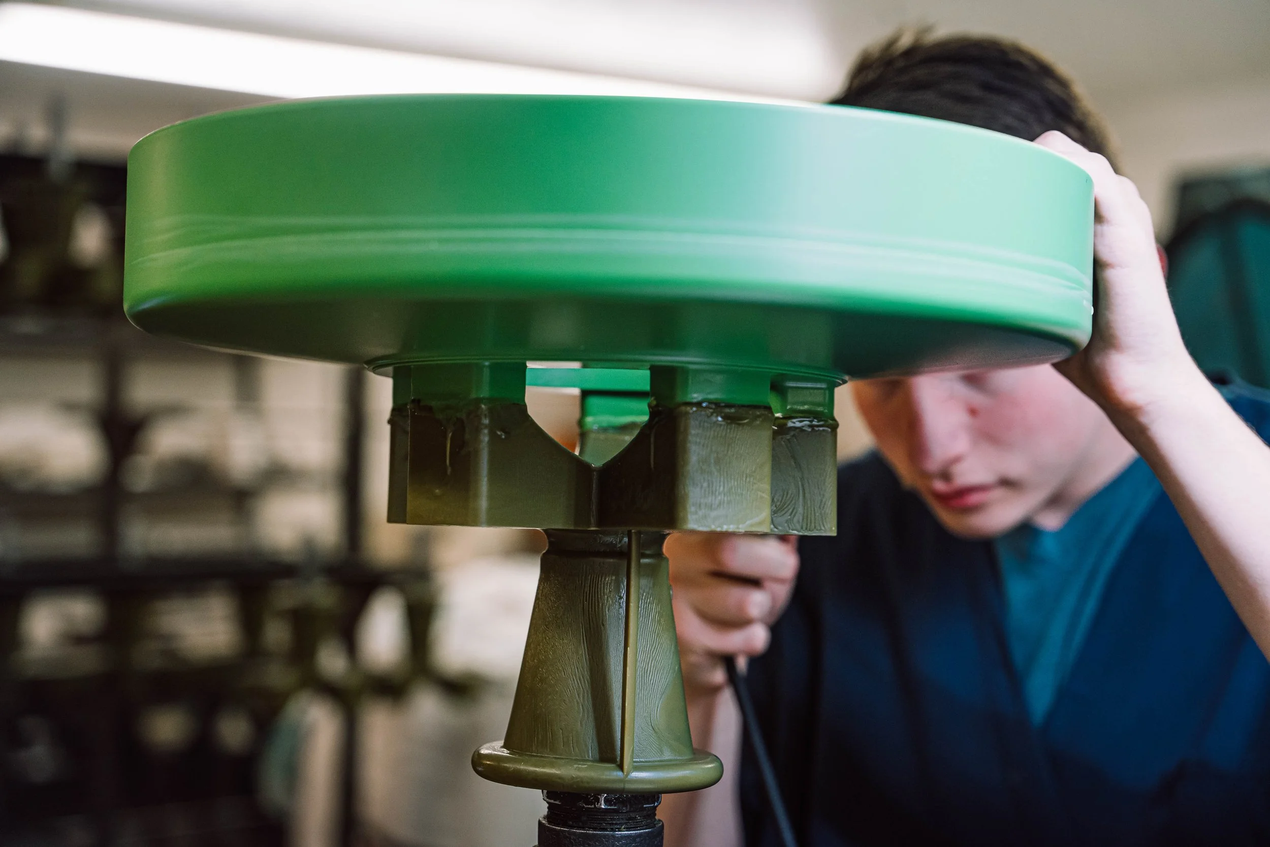 A Foundry worker affixing a gate to a singular large wax pattern.