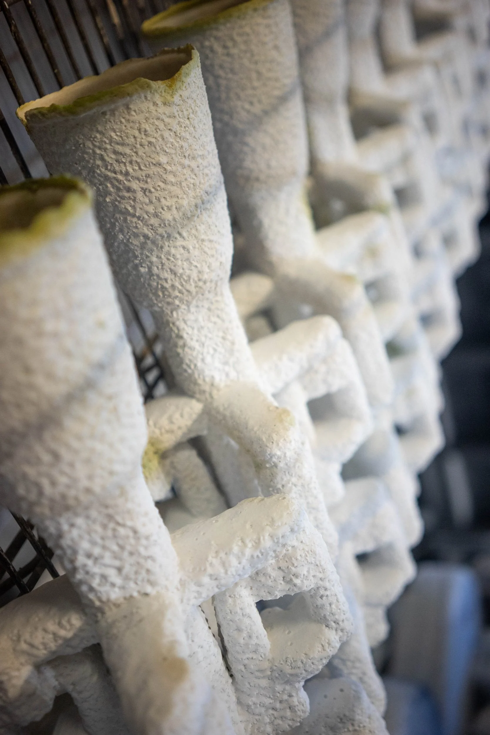 Hollow ceramic shells staged for pouring during the investment casting process.