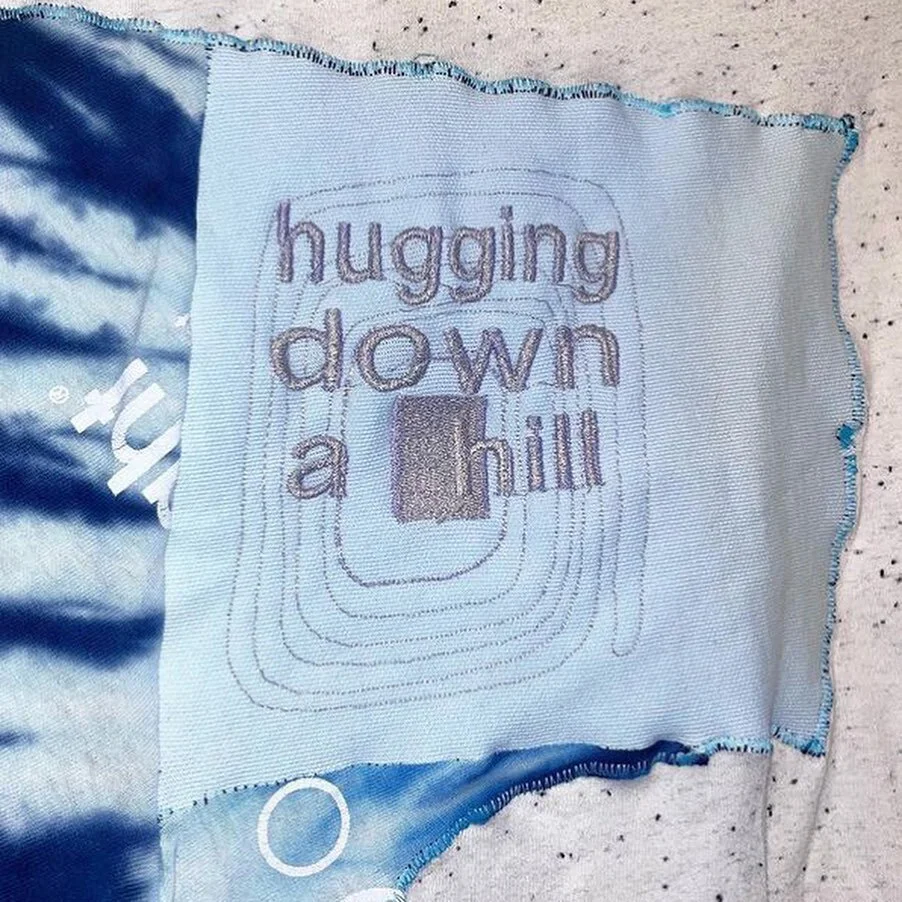 We are so excited to host Cal Fish ( @cazet_travela ) at our market this Sunday! 

Cal Fish is a cross-medium artist who produces clothing and soft sculpture using up-cycled materials. Embroidered drawings and text blend textile detritus and sentimen