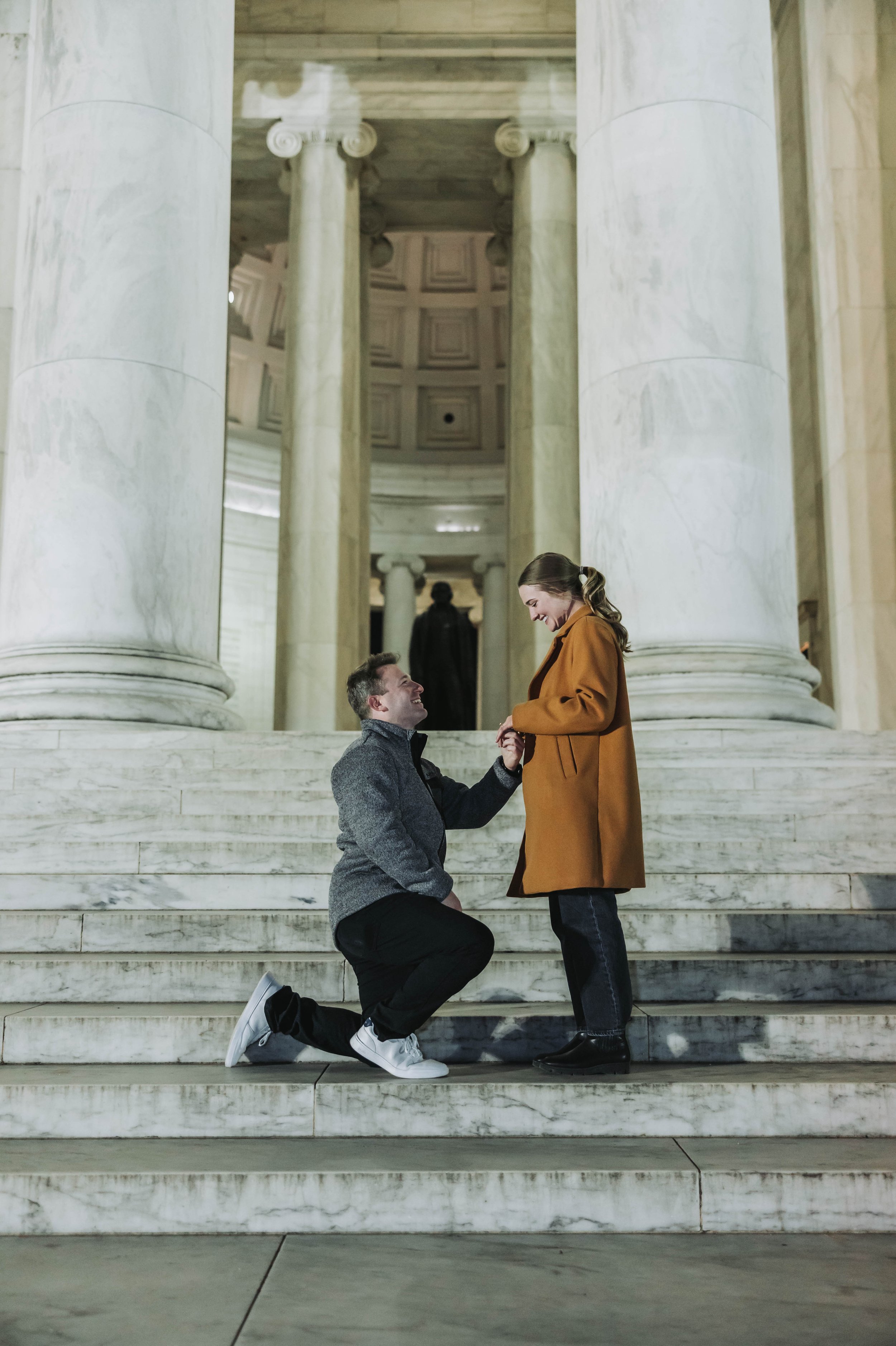 A man proposes to a woman on the steps of the Jefferson Memorial.