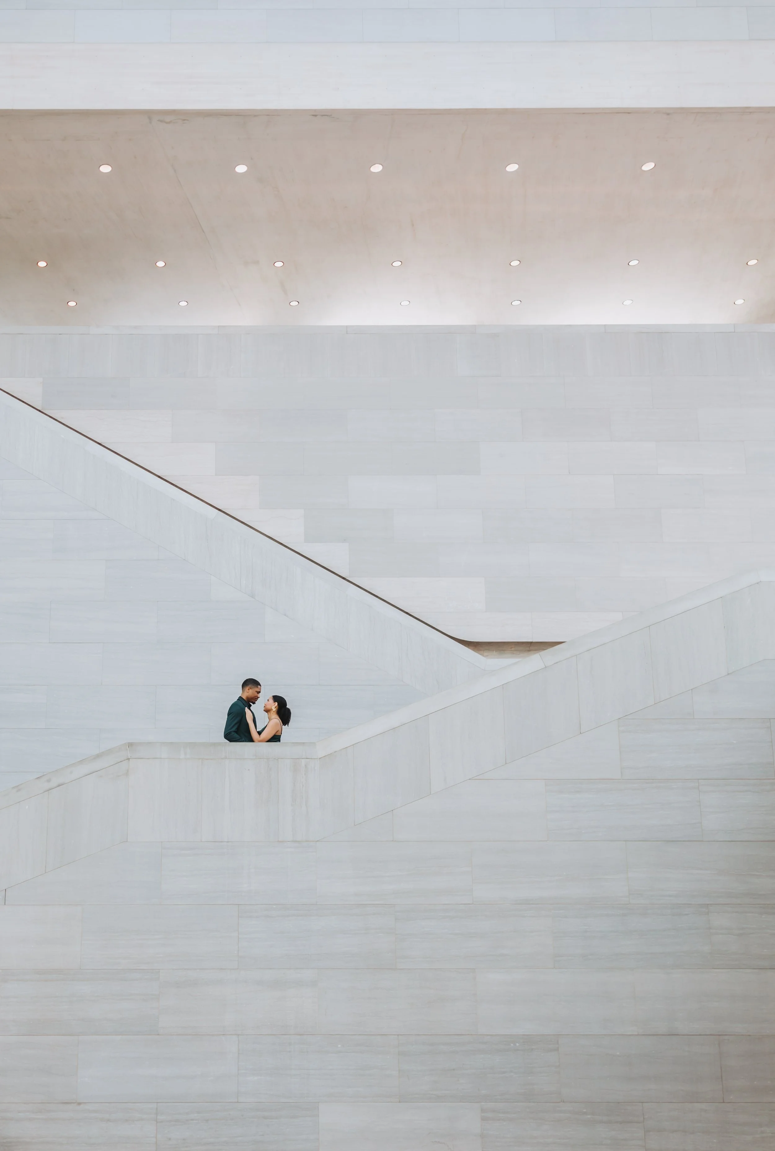 Couple posing on the staircases in the National Gallery of Art East Building.