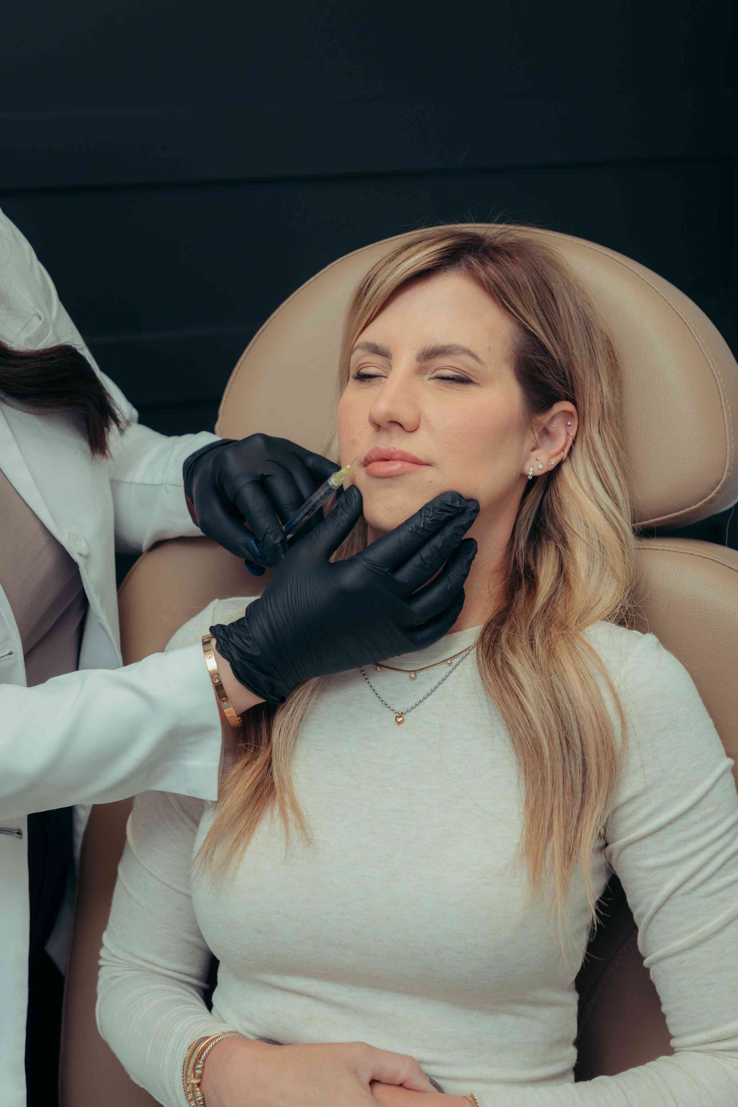 Client relaxed with eyes closed during a lip filler treatment at a med spa offering lip fillers near Peoria, AZ.