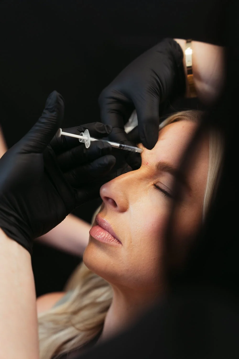 Woman receiving a professional facial treatment at a med spa, answering the common question: can you do red light therapy after botox?