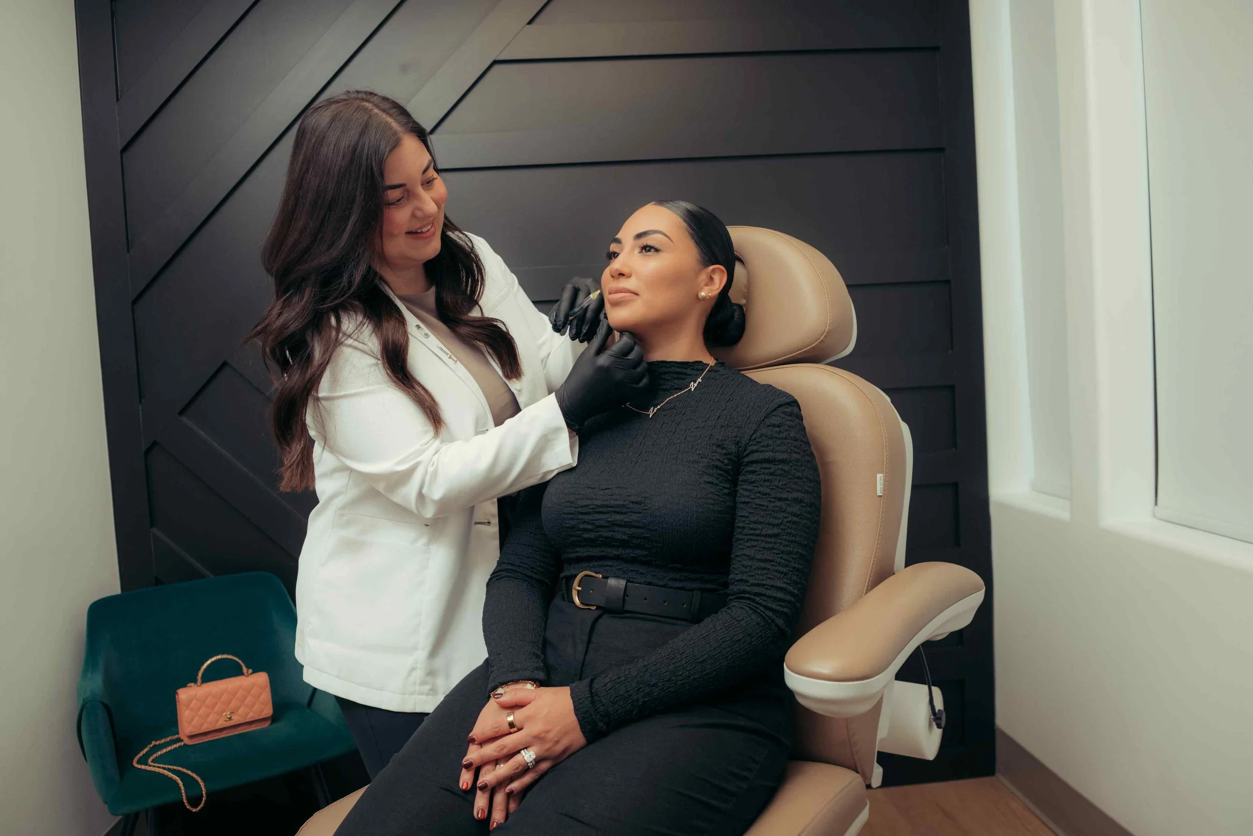Injector and smiling client during a lip fillers Peoria, AZ consultation in a modern treatment room.