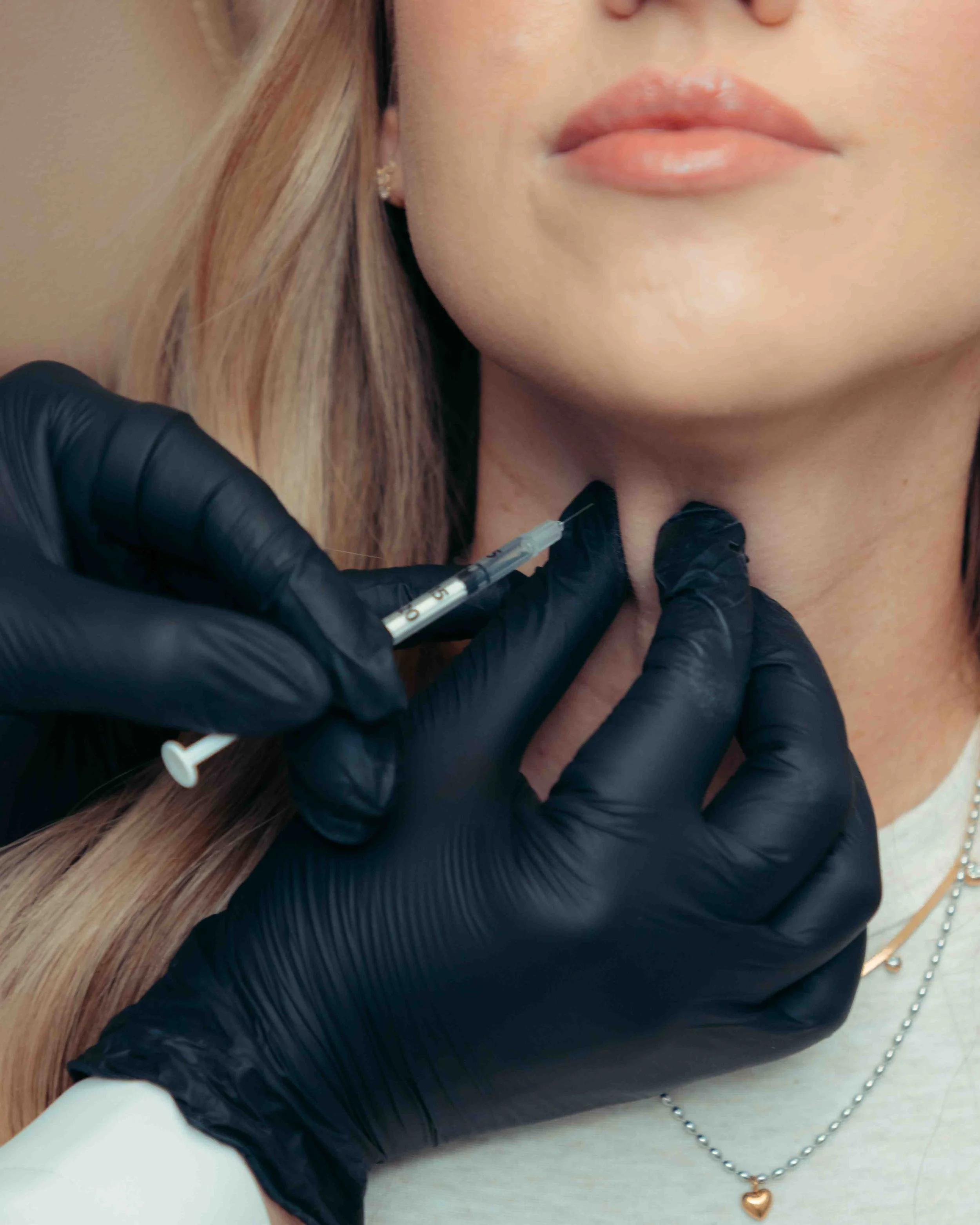 A patient getting botox injections in their neck at INJX Bar in Peoria, AZ.