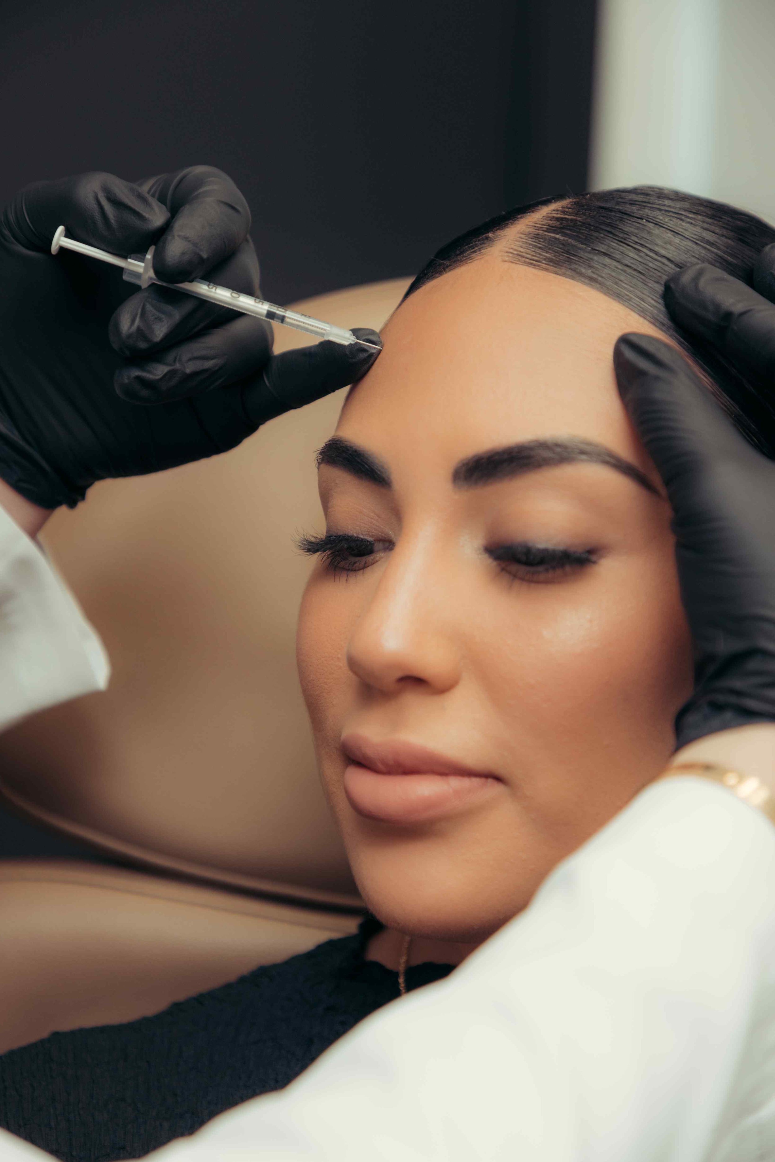 A patient getting botox injections in their forehead to reduce facial wrinkles and lines.