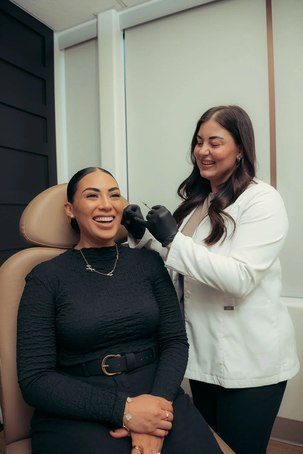 Two women discussing Daxxify cost and treatment benefits at a med spa.