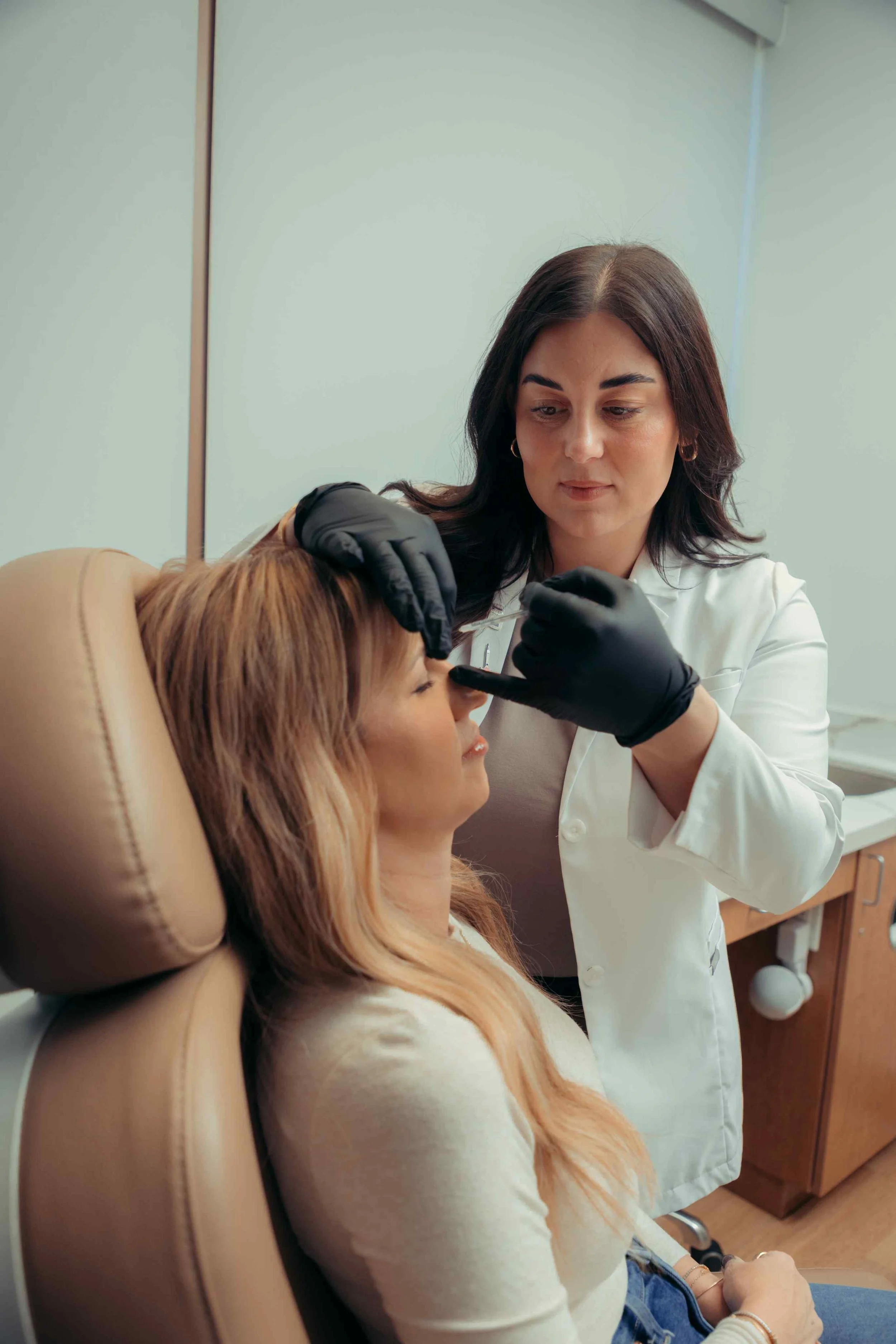 Professional injector at INJX Bar in Peoria, AZ treating a patient's wrinkles with botox injections.