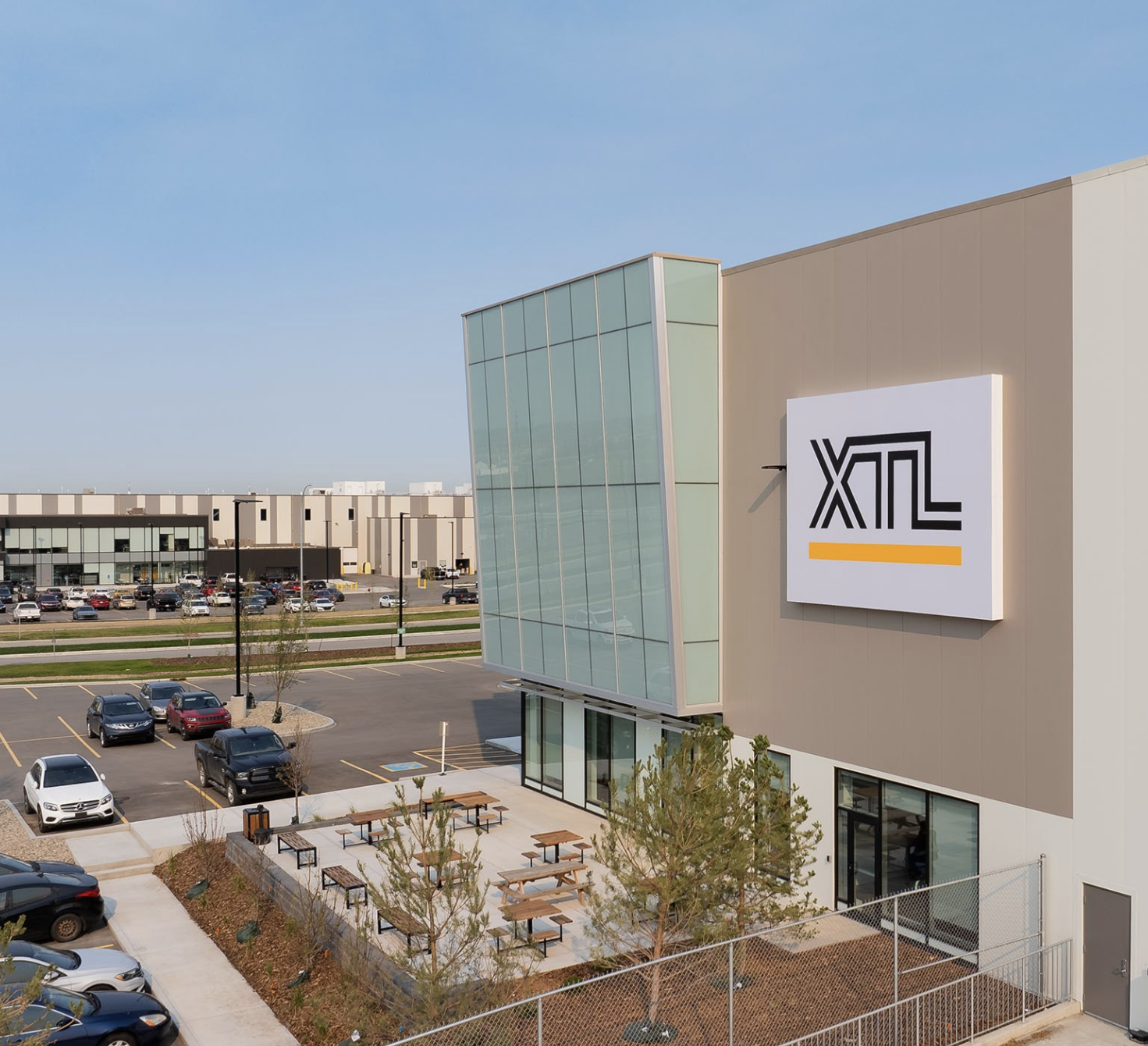 Modern warehouse space built for XLT Transportation. This image features the front entrance, parking, and outdoor seating area.