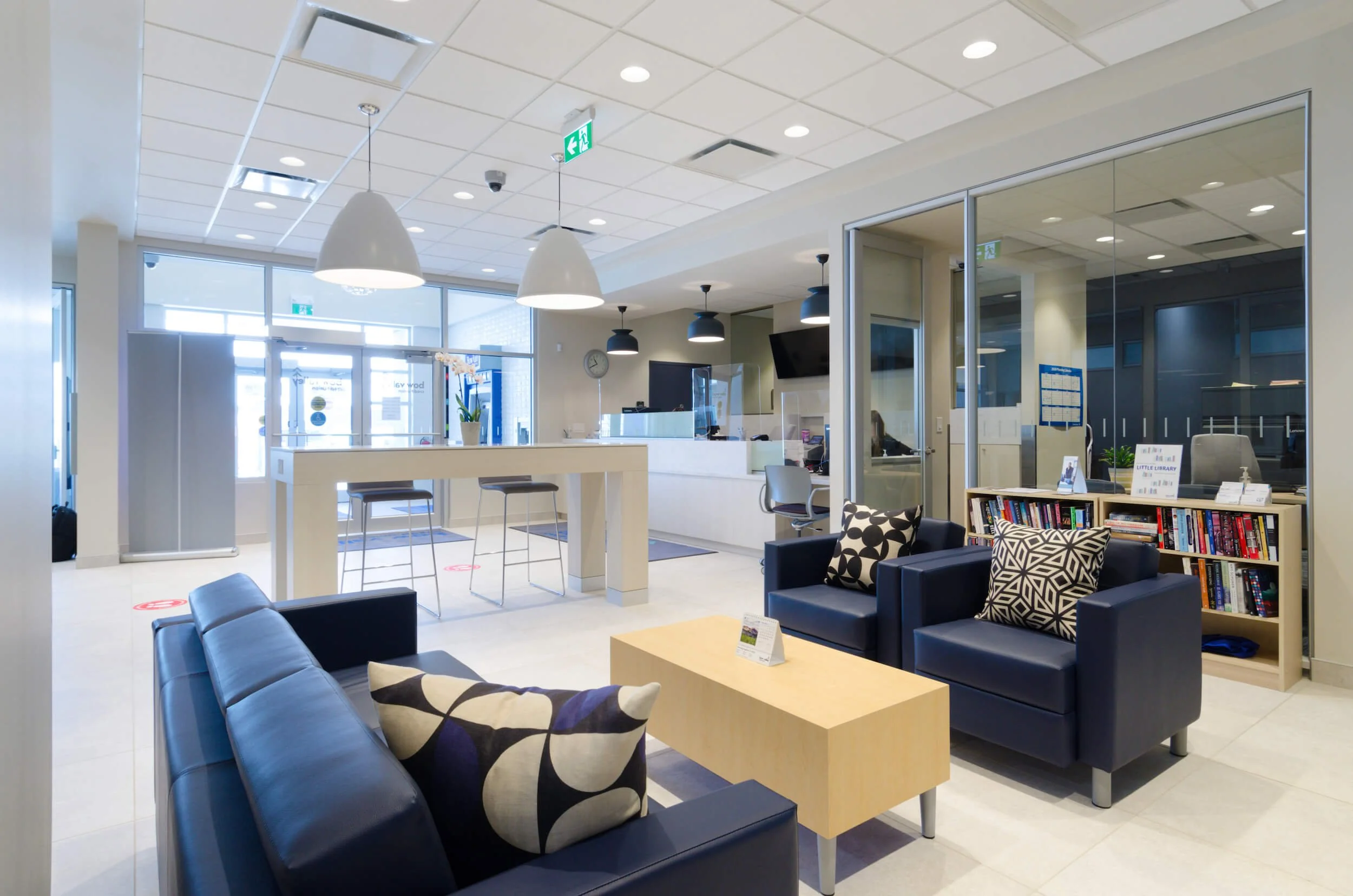 Bow Valley Credit Union Sage Hill lobby with seating area, bookshelves, and reception desk in a public building