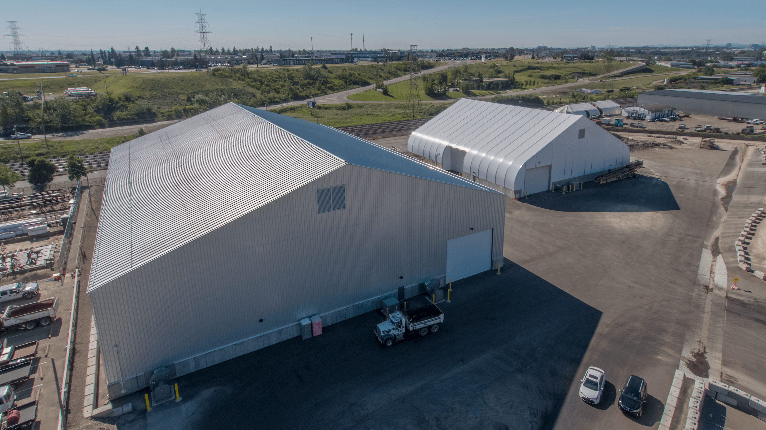 A landscape view of two silver industrial work buildings