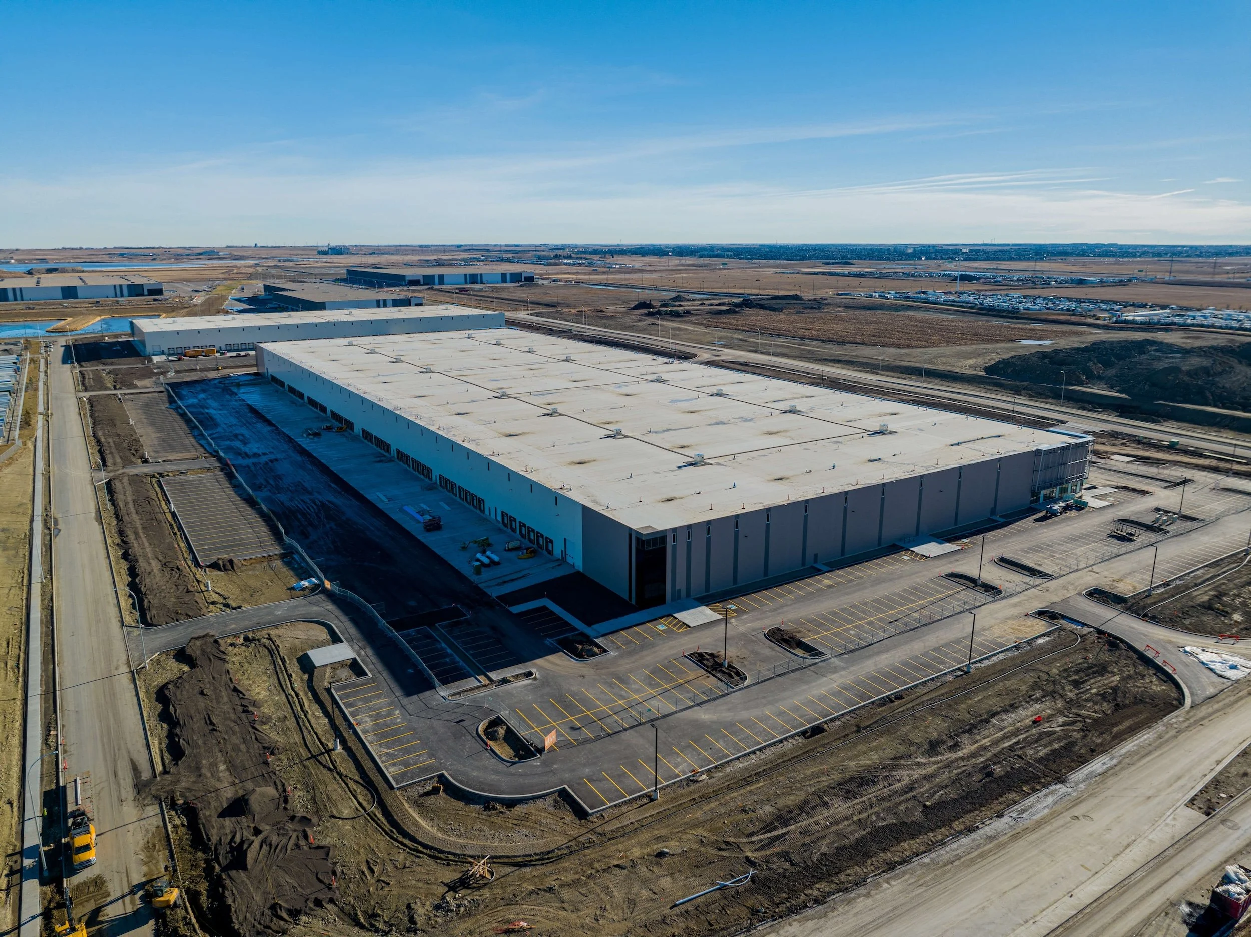 A top view of an industrial warehouse construction build by elan in nose creek calgary alberta surrounded by unfinished landscaping