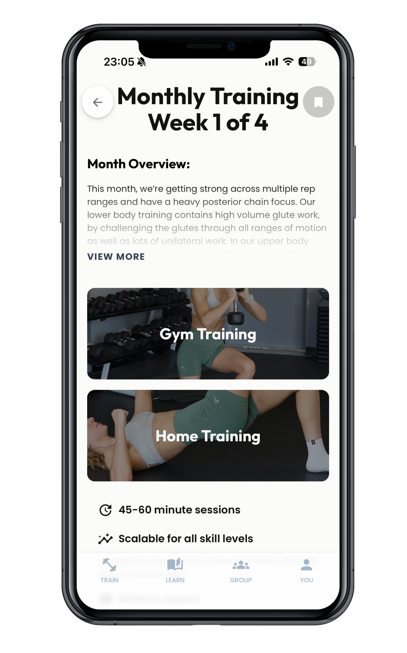 Mobile app screen displaying a workout program titled 'Monthly Training Week 1 of 4.' It includes sections for Gym Training and Home Training, with images of women exercising. The app mentions 45-60 minute sessions and scalability for all skill levels, with navigation icons at the bottom labeled Train, Learn, Group, and You.