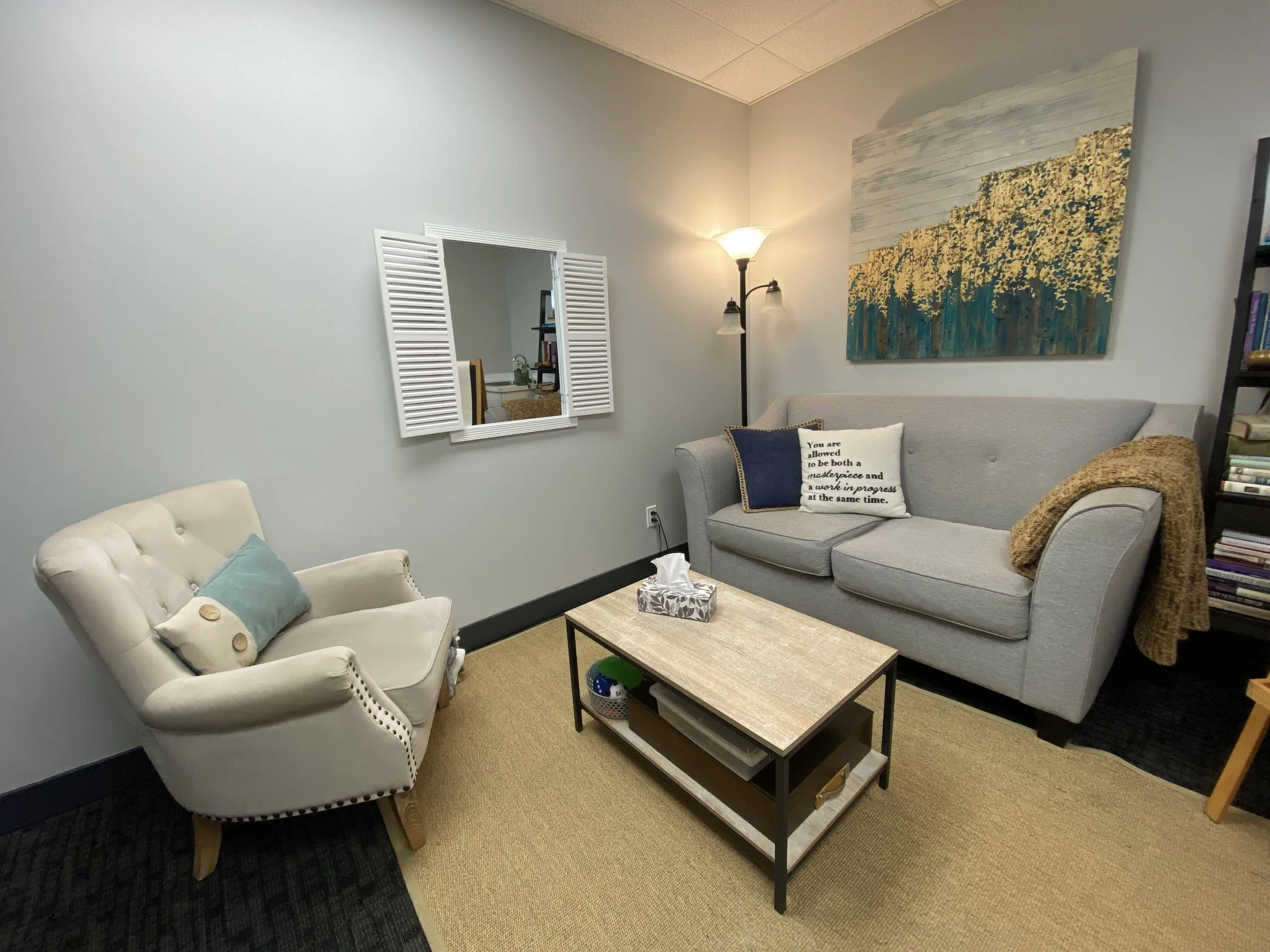 Our welcoming counselling office space in Maple Ridge, BC. The image features a soft beige arm chair and a soft grey couch with blue throw cushions.