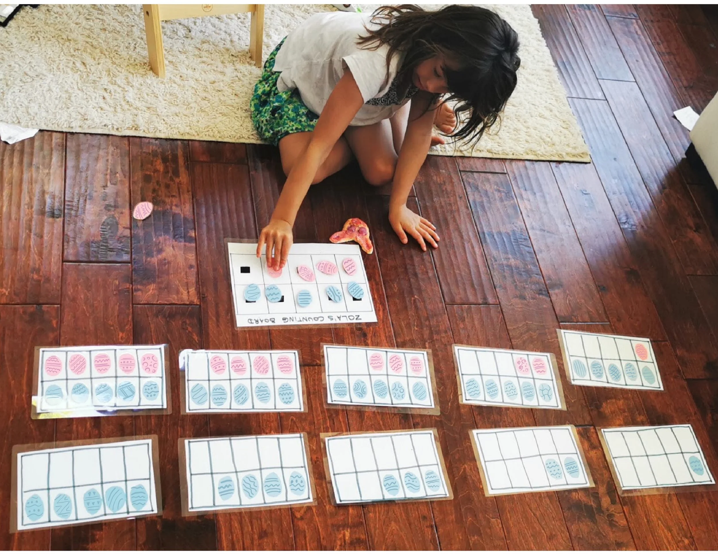 Child using a ten frame with Easter eggs to practice addition and subtraction by adding and removing objects for hands-on math learning